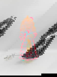 Victorian-Style Porcelain Doll in Holiday Dress: Collectible porcelain doll with curly auburn hair and hand-painted facial features. Dressed in a festive plaid gown accented with lace, ribbon, and a red rose bonnet. The doll holds a small woven