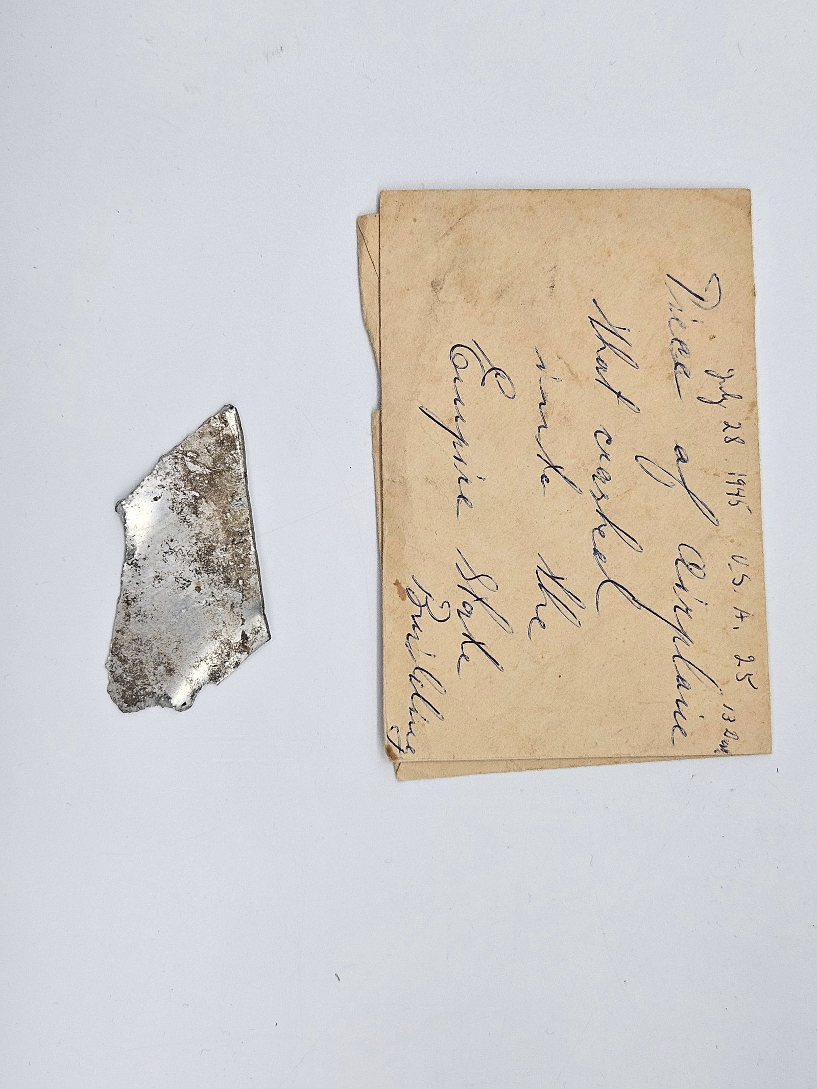Fragment from 1945 Empire State Building Airplane Crash: Small metallic fragment accompanied by a handwritten note reading, “Piece of airplane that crashed into the Empire State Building, 1945.” The relic is believed to originate from the U.S. A