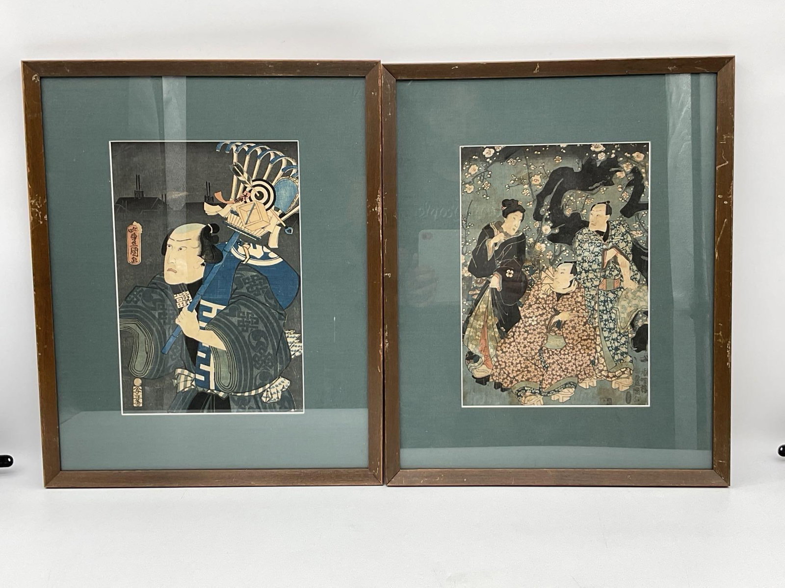 Pair of Framed Japanese Woodblock Prints: Pair of framed Japanese woodblock prints depicting figures in traditional dress. Each print is framed and matted. Dimensions: H21in L17in.