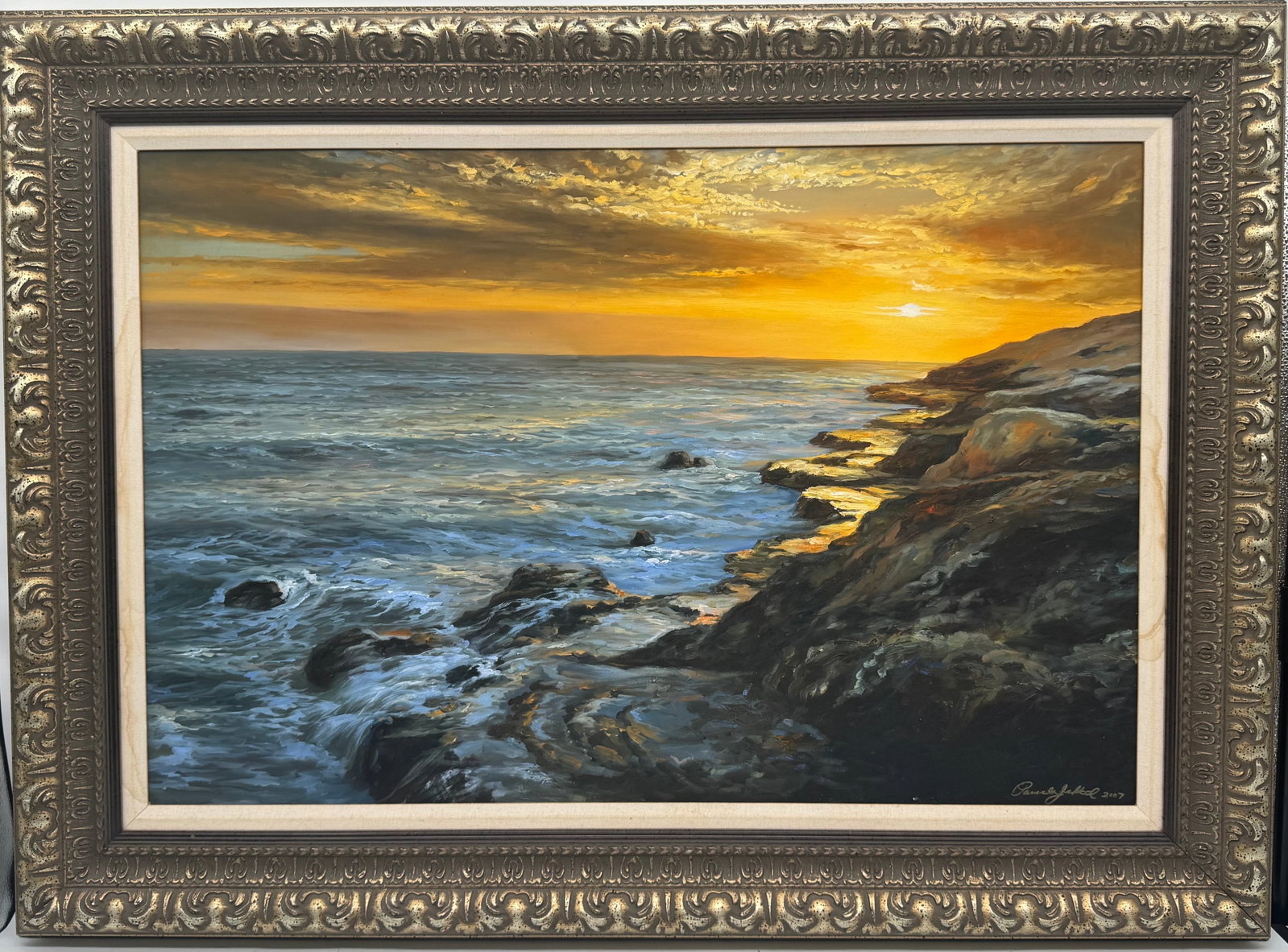 Coastal Sunset by Pamela Jekel (American, b.1948) Oil on Canvas: Description: Pamela Jekel (American) Coastal Sunset, 2007. Oil on canvas, signed lower right and dated. Depicts a rocky coastline at sunset with golden light reflecting on the water and rocks. Framed.