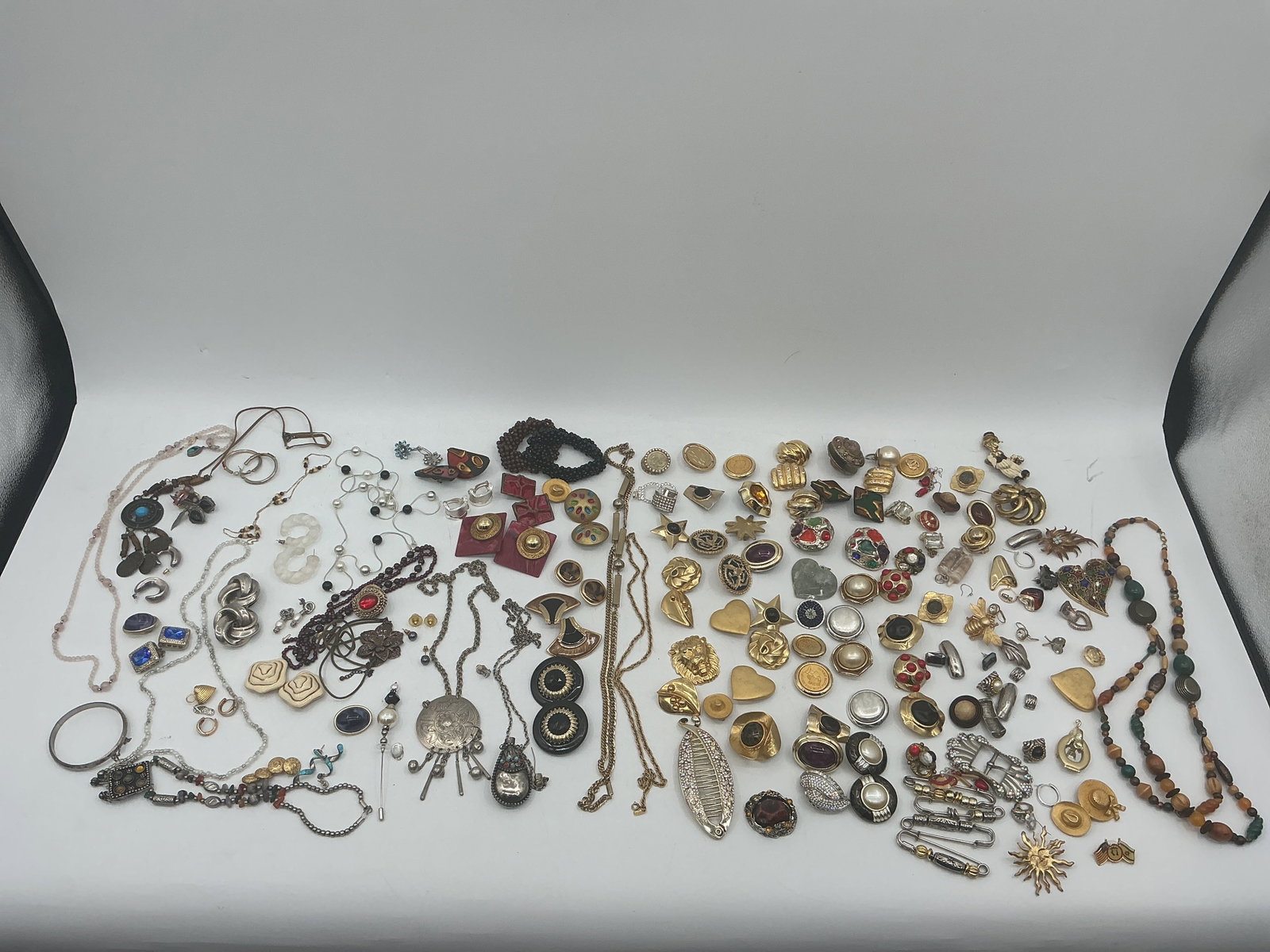 Large Assortment of Costume Jewelry: A large collection of costume jewelry including necklaces, earrings, rings, brooches, and other assorted pieces. Various styles and materials are represented.