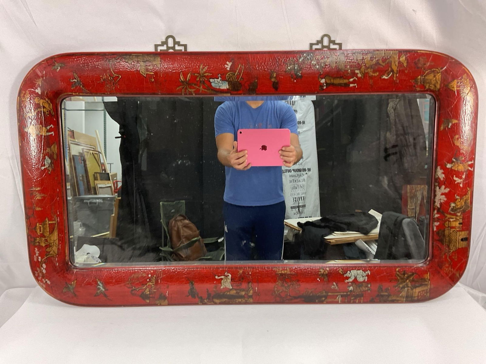 Vintage Chinoiserie Red Lacquered Mirror: A stunning vintage or antique mirror with a bold red lacquered frame, decorated in a Chinoiserie style featuring hand-painted Asian-inspired scenes of figures, animals, trees, and landscapes. The roun