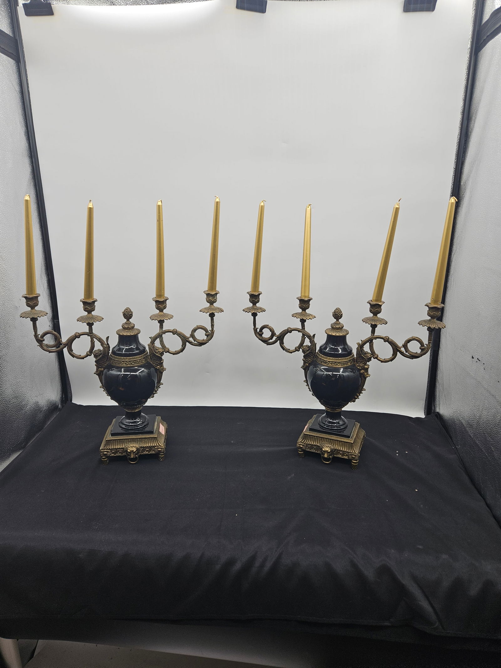 Pair of Bronze and Black Ceramic Candelabras: Pair of ornate candelabras featuring bronze arms and bases with black ceramic urn-shaped bodies. Each candelabra holds five candles. Dimensions approximately 18 x 21 x 5 inches each.