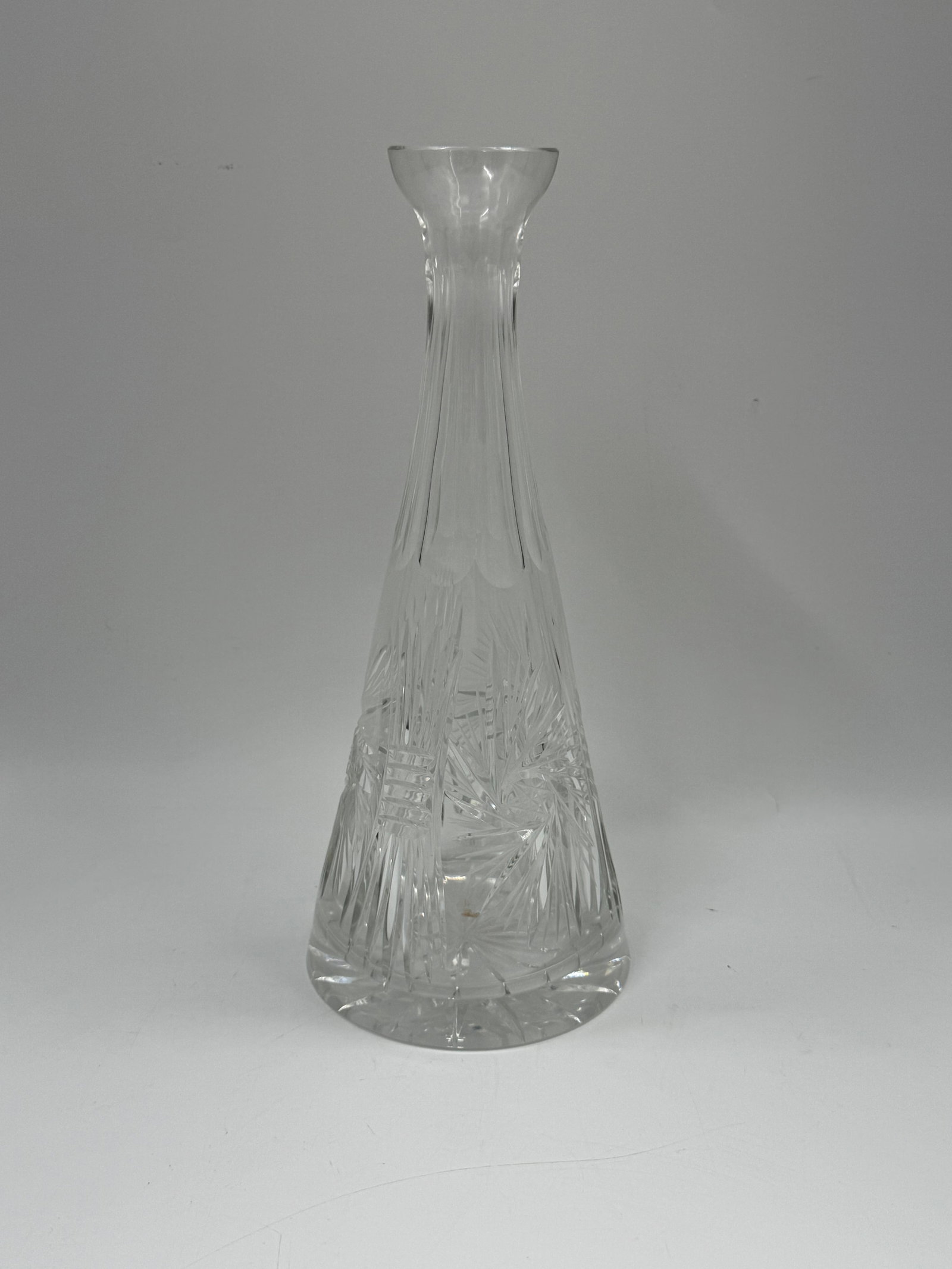 Cut Crystal Glass Bud Vase: Elegant cut crystal glass bud vase. Features a flared rim and intricate cut designs throughout the body. Measures approximately 12 inches tall and 5 inches wide.