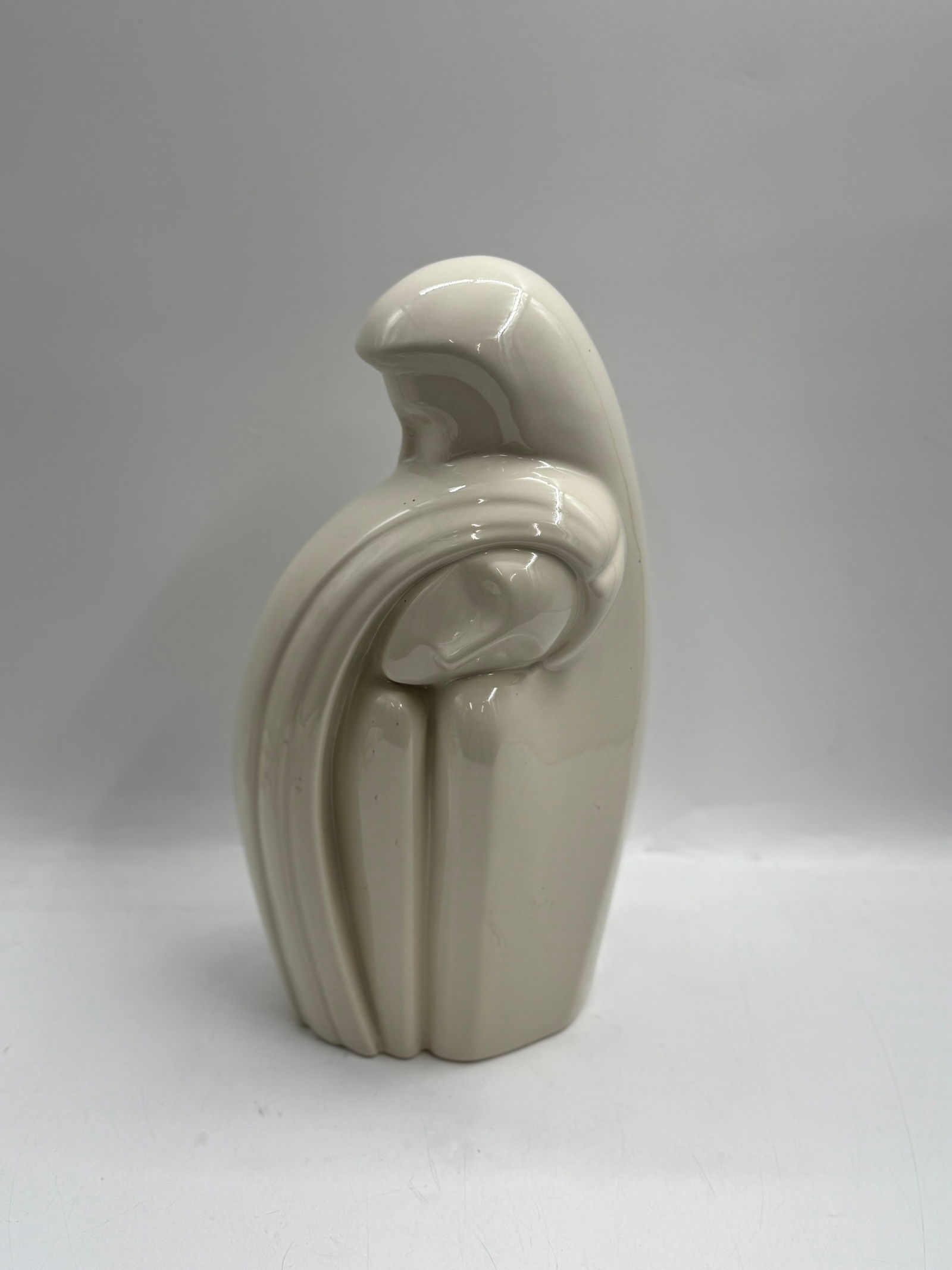 Haegar "Lovers Embrace": A modern ceramic sculpture of a mothers embrace by Haeger Pottery. The piece features a minimalist design with flowing lines and a smooth, off-white glaze. Dimensions: H: 18in W:7in L:7in