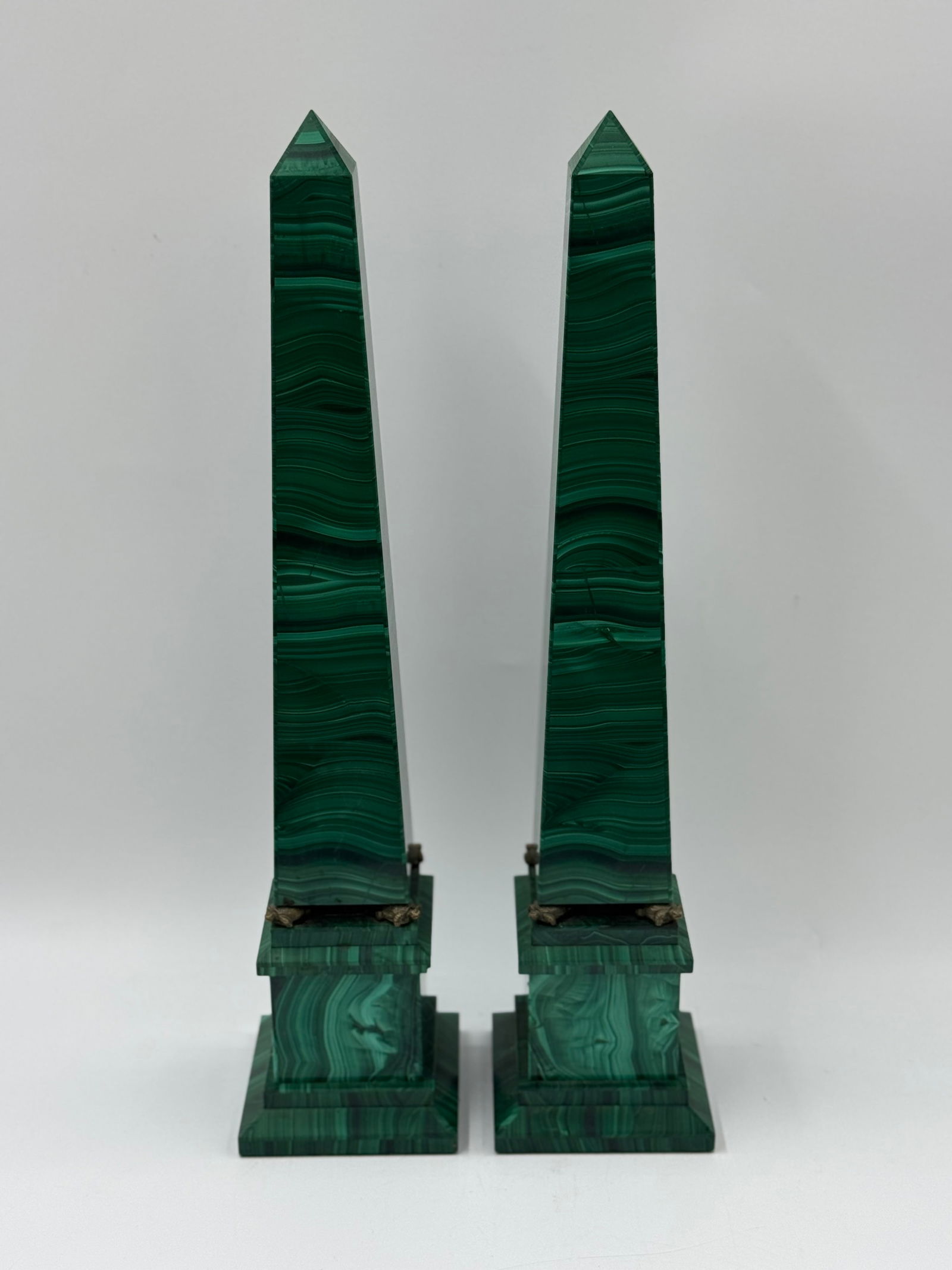 Pair of Malachite Obelisks: Pair of malachite obelisks, each mounted on a tiered base with bronze accents. Each measures approximately 18.5 x 4 x 4 inches.