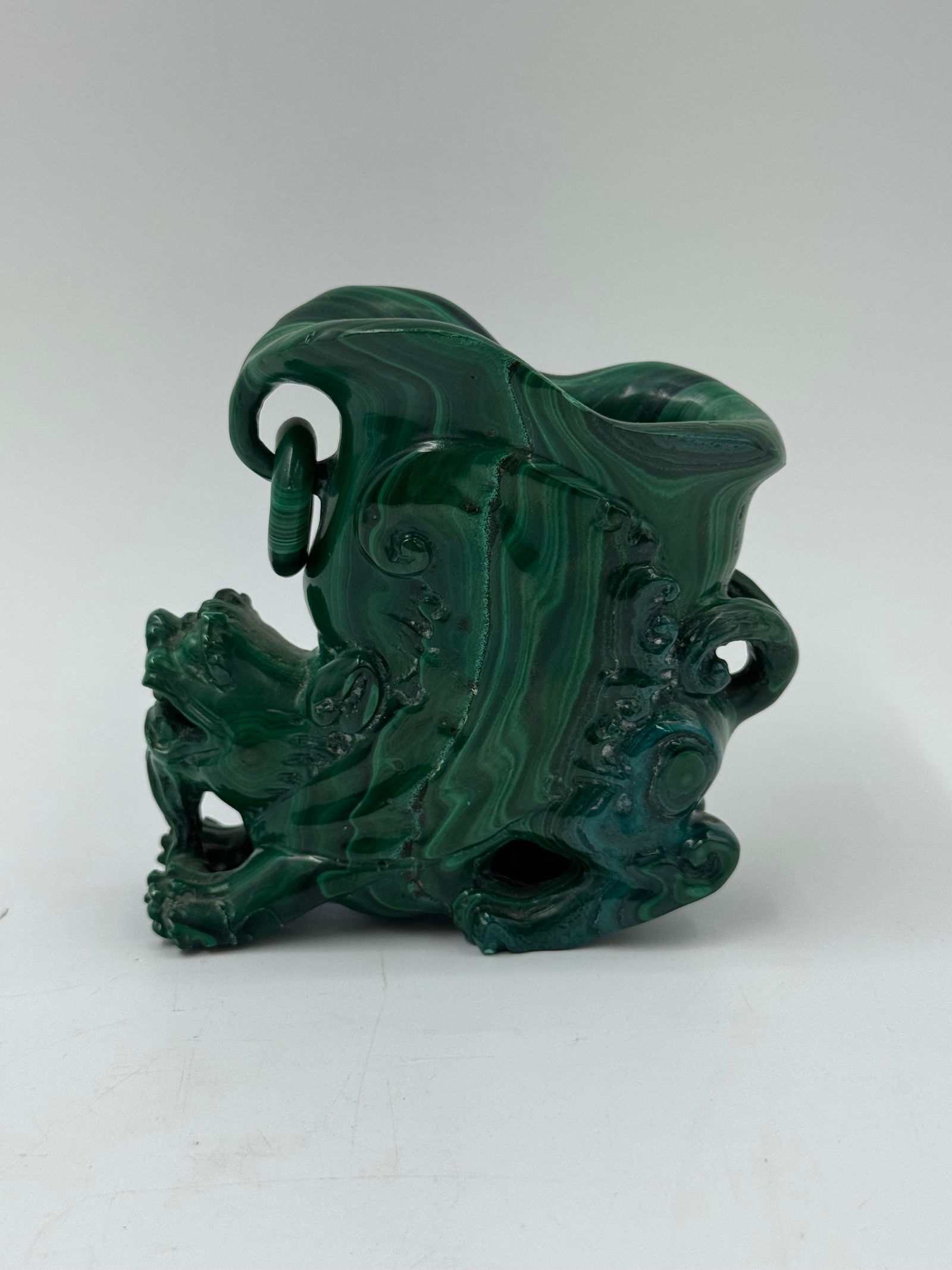 Malachite Carved Dragon Sculpture: A carved malachite sculpture depicting a dragon. The piece features intricate details and the characteristic banding of malachite. Dimensions approximately 3.5 x 3.5 inches.