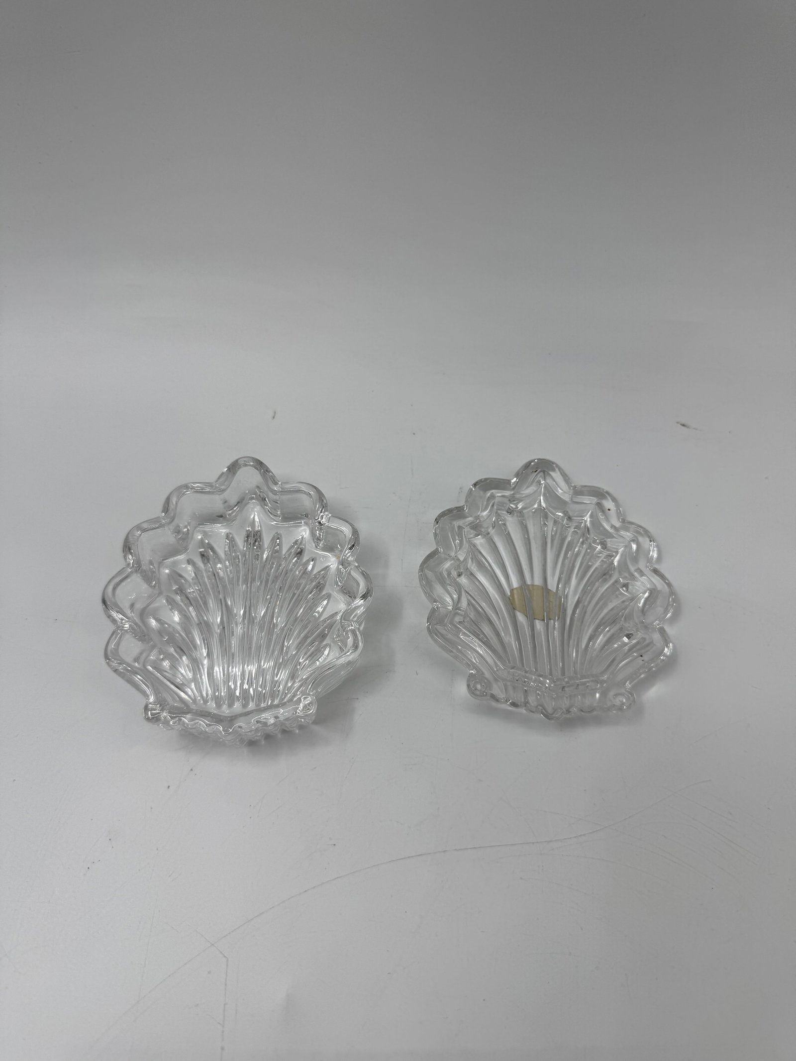 Pair of Clear Glass Seashell Dishes: Pair of clear glass dishes molded in the shape of seashells. Each measures approximately 4 x 3.5 inches.