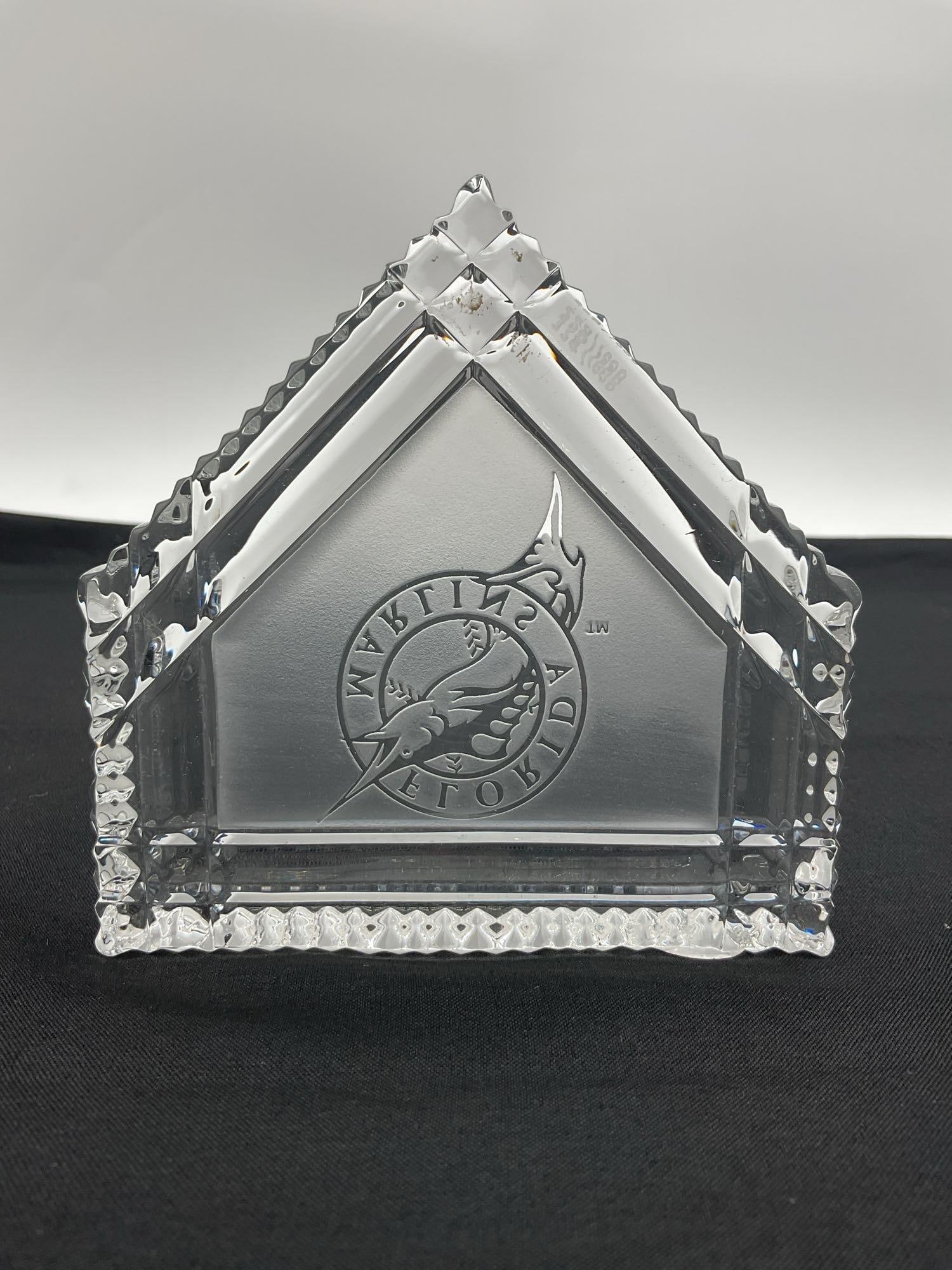 Waterford Crystal Florida Marlins Logo Paperweight: This Waterford Crystal paperweight is designed in the shape of a house or peaked structure and features the Florida Marlins logo etched in the center. The intricate cuts and beveled edges showcase Wat
