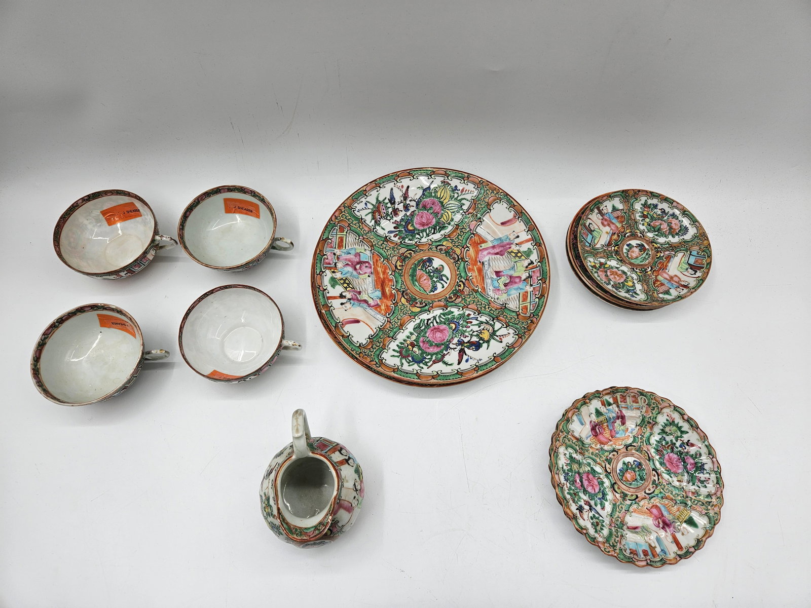 Chinese Rose Medallion Porcelain Tea Set: A partial Chinese Rose Medallion porcelain tea set featuring intricate hand-painted designs with floral, bird, and figure motifs in vibrant pink, green, and gold tones. The set includes cups, saucers,