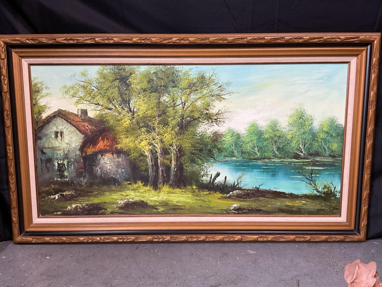 Cabin and lake landscape painting by Heller: Serene oil painting signed Hiller depicting a rustic cabin by a lake surrounded by trees and soft natural light Medium: Oil on canvas in decorative gold frame