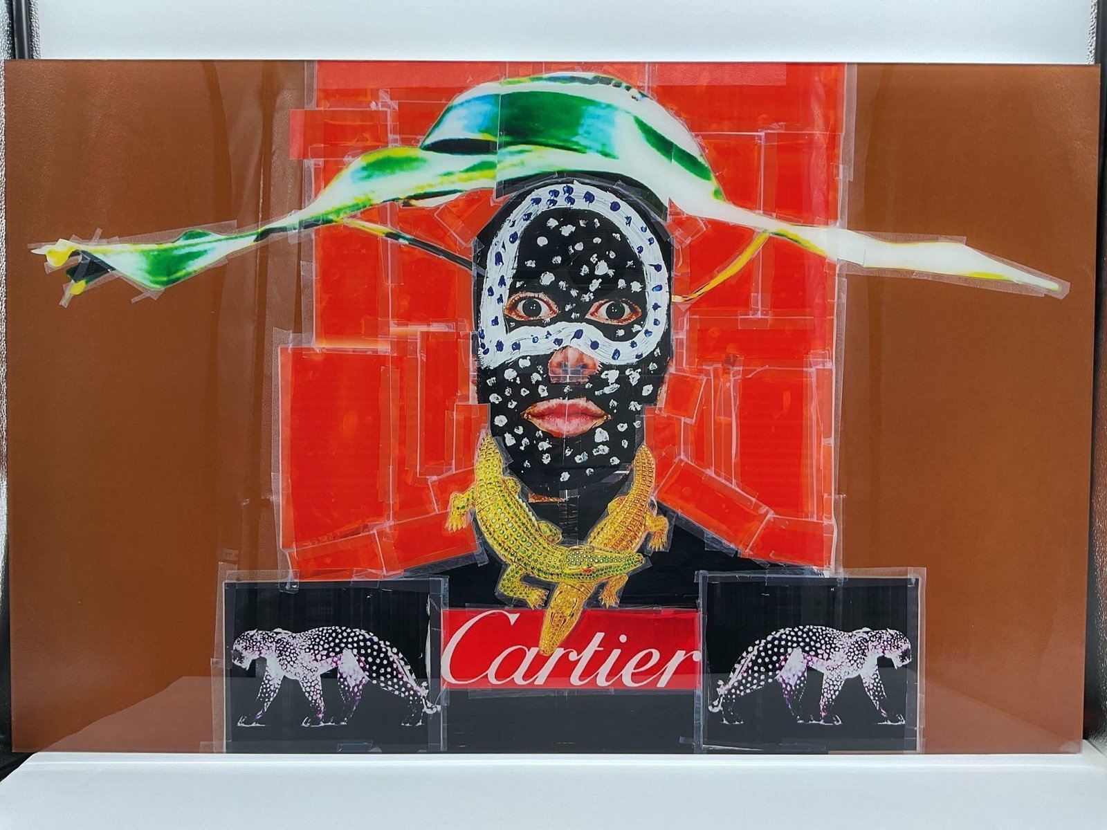 Cartier Warrior by Carlos Felix (Mexico, B. 1981): Bold mixed media portrait on a burnt orange background, depicting a stylized face adorned with tribal-inspired patterns, dramatic textures, and metallic accents. The figure’s garment features th