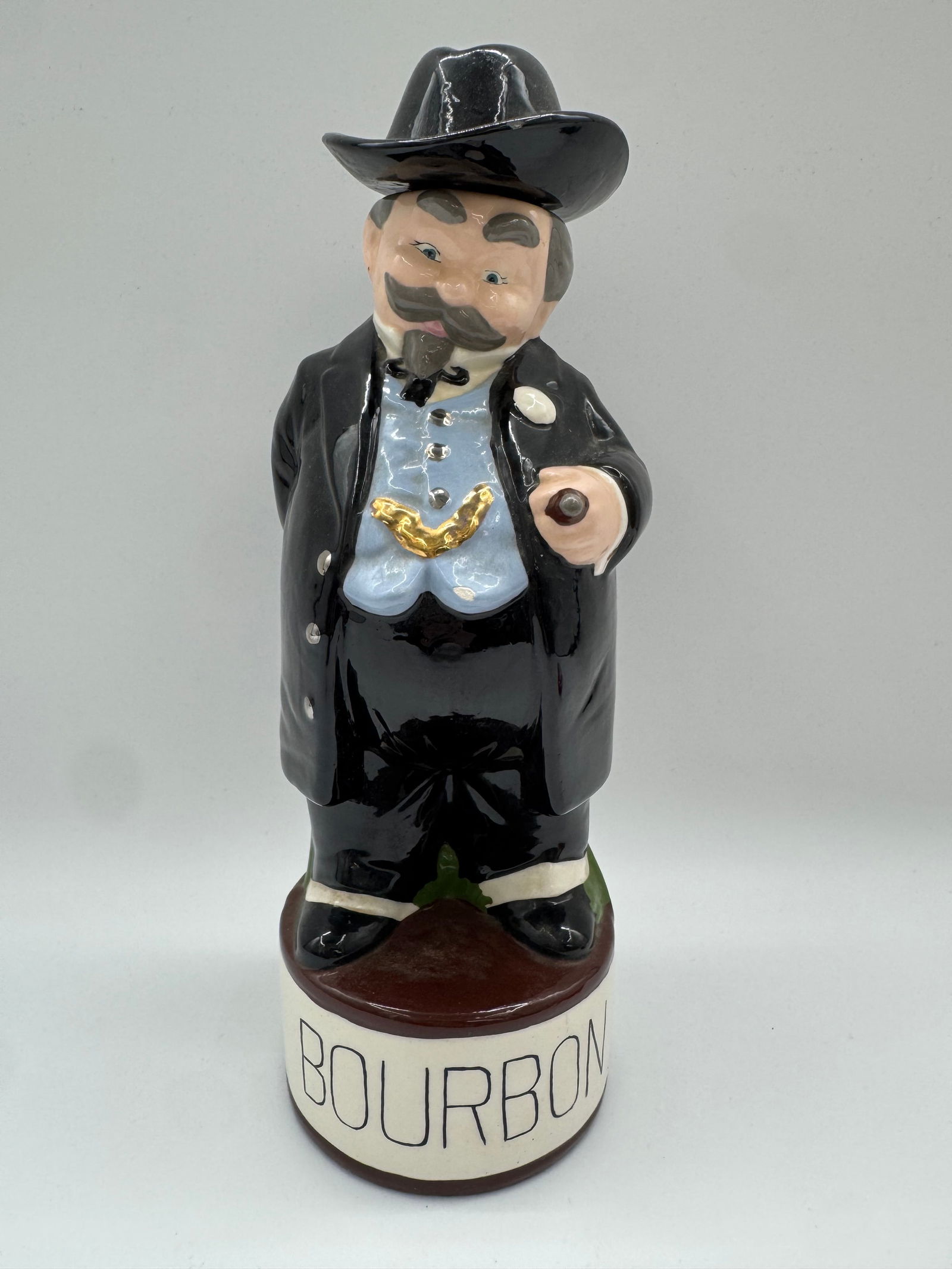 Vintage “Bourbon Gentleman?? Character Decanter, Hand-Painted Ceramic, c.1960s: Charming vintage ceramic character decanter featuring a bearded gentleman in a black suit and hat, holding a cigar and standing atop a base boldly labeled