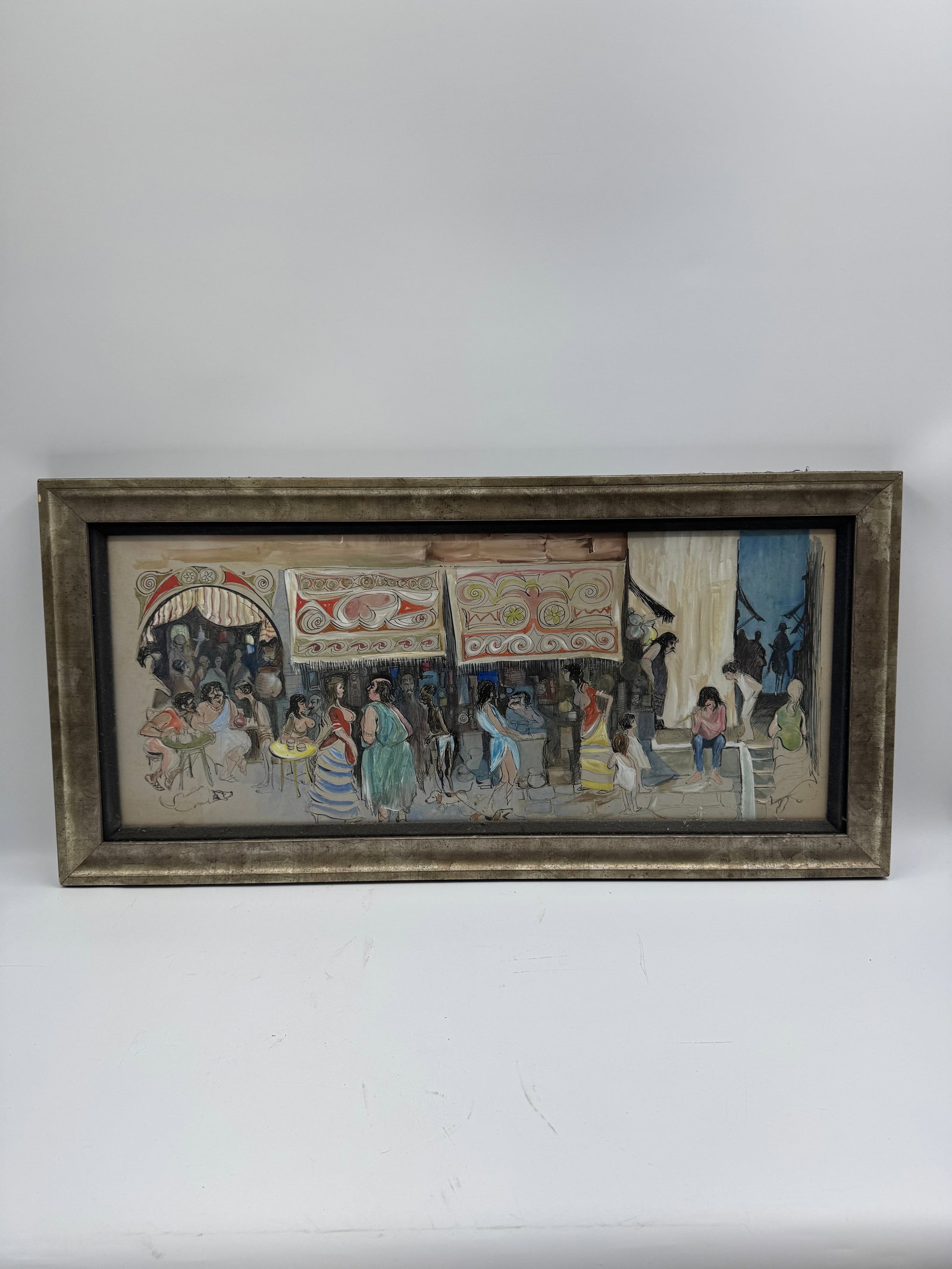 Framed Street Scene Painting: Framed painting depicting a bustling street scene with figures and market stalls. The artwork is presented in a decorative frame. Dimensions: 34 x 17 inches.