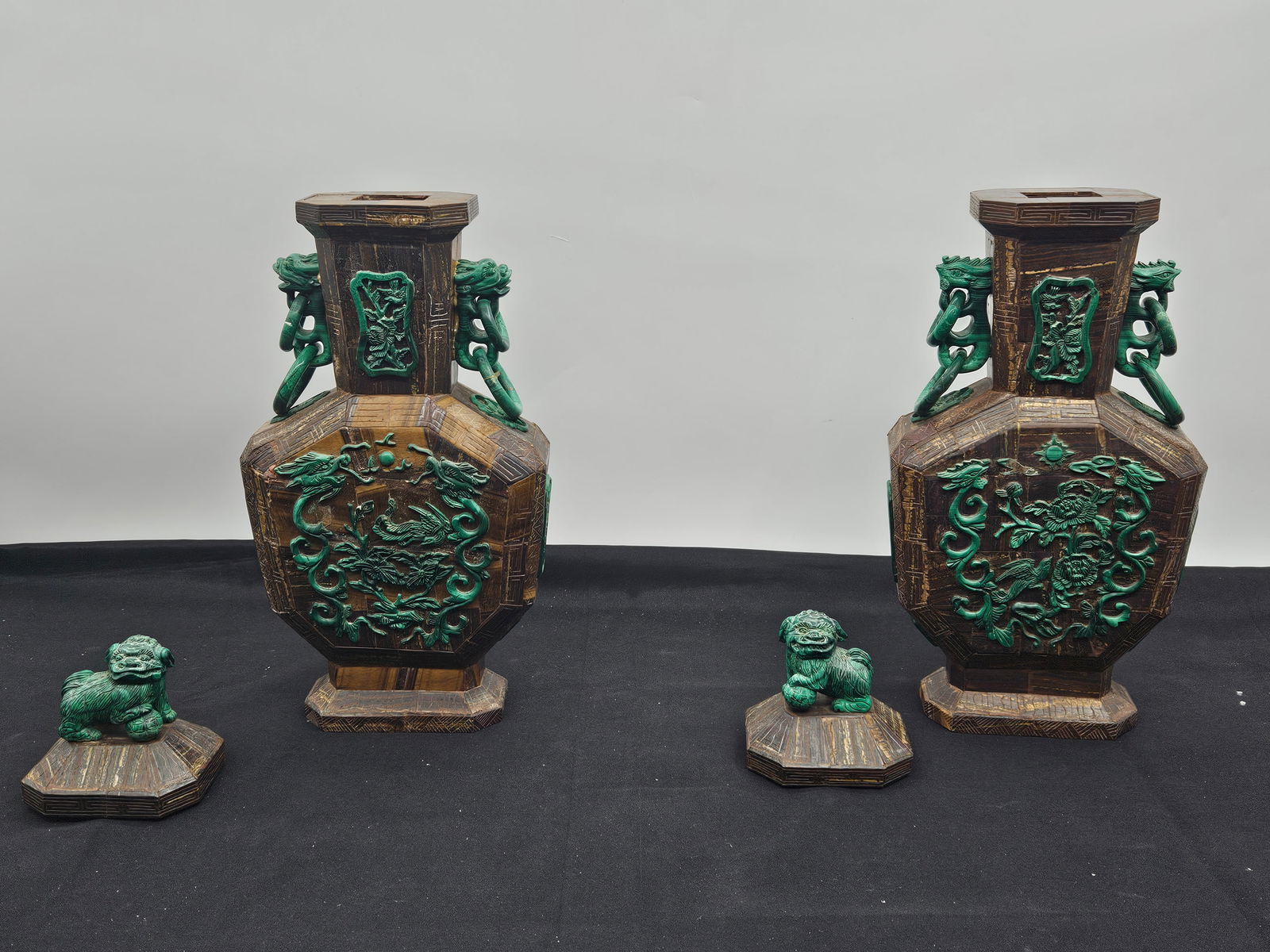 Pair of Chinese Carved Wood & Malachite Vases with Foo Dogs: Pair of Chinese vases featuring carved wood bodies with applied malachite carvings. Each vase is adorned with foo dog finials and handles, and detailed panels. Each vase comes with a matching foo dog