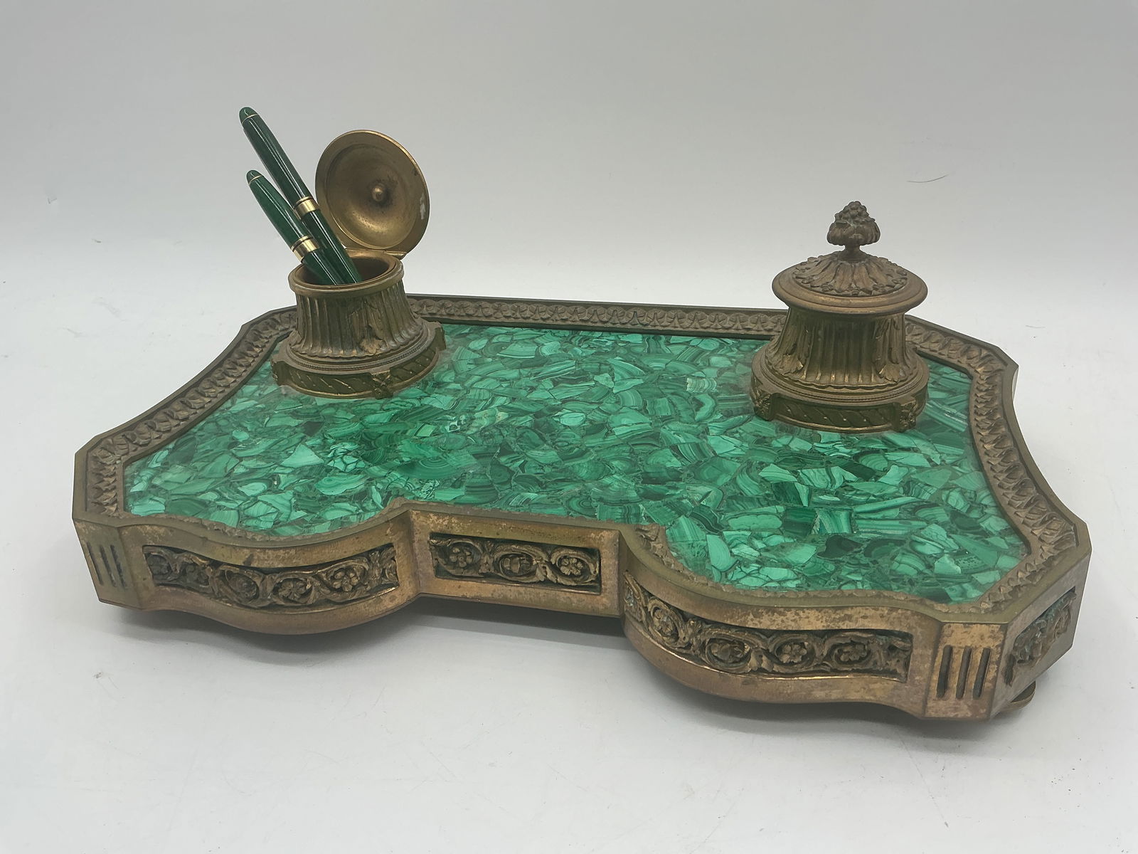 Malachite and Bronze Desk Set with Pens: Malachite and bronze desk set featuring a pen holder with lid and an inkwell with lid. Includes two malachite pens, one a calligraphy pen. Dimensions: 5.5" H x 16" L x 9.5" W. Pen lengt