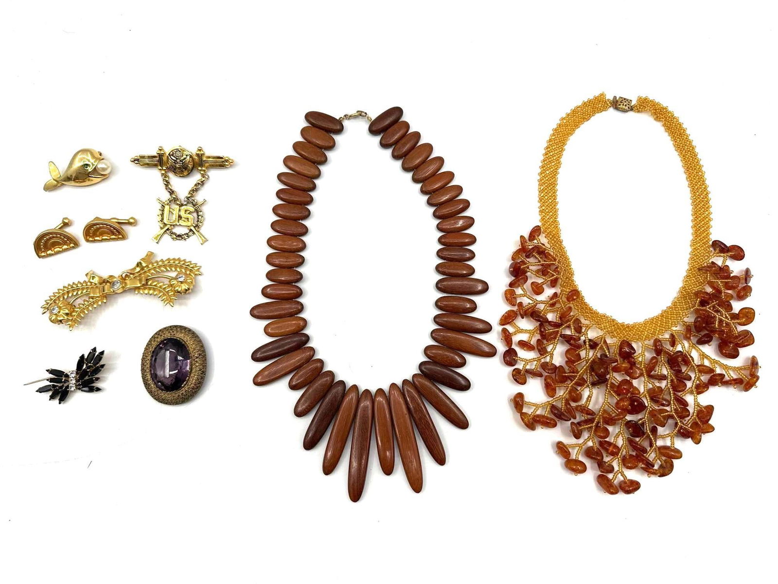 Assorted Vintage Jewelry Collection – Necklaces, Brooches, and Earrings: Eclectic group of vintage costume jewelry including two statement necklaces—one with amber-colored beads and netting, and another with elongated wooden beads. The lot also features a variety of