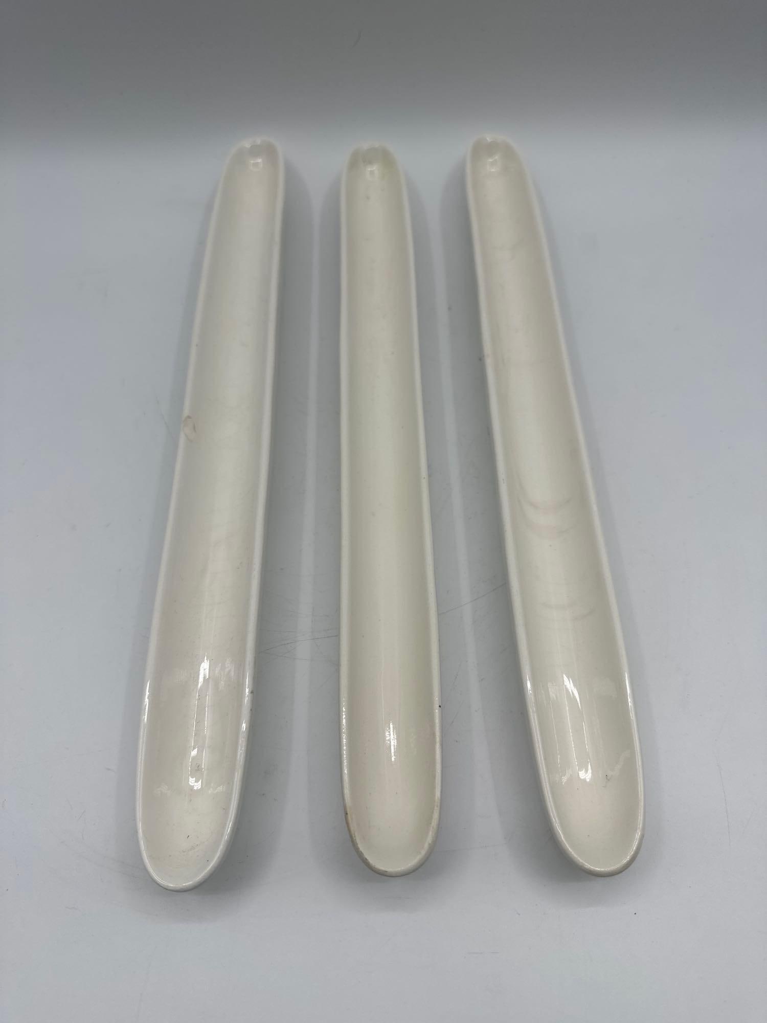 Set of Three Vintage Milk Glass Celery Trays: Trio of elongated milk glass trays with ribbed detailing, traditionally used for serving celery or hors d’oeuvres. Dimensions: H:1in L:16.5in W:1.5in