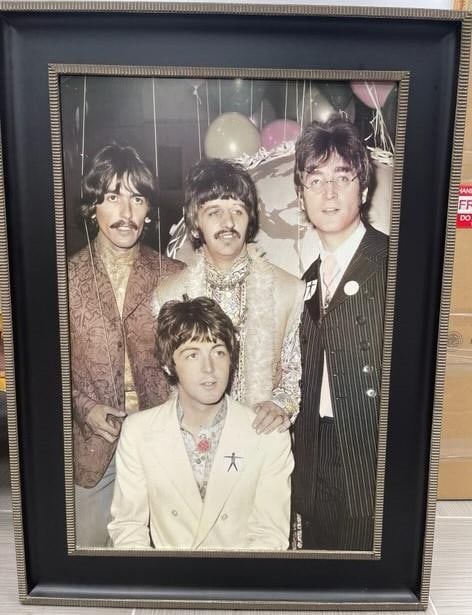 Framed Vintage Photograph of The Beatles: This is a framed vintage photograph of The Beatles, featuring George Harrison, Ringo Starr, John Lennon, and Paul McCartney dressed in psychedelic era clothing, indicative of the late 1960. The backgr