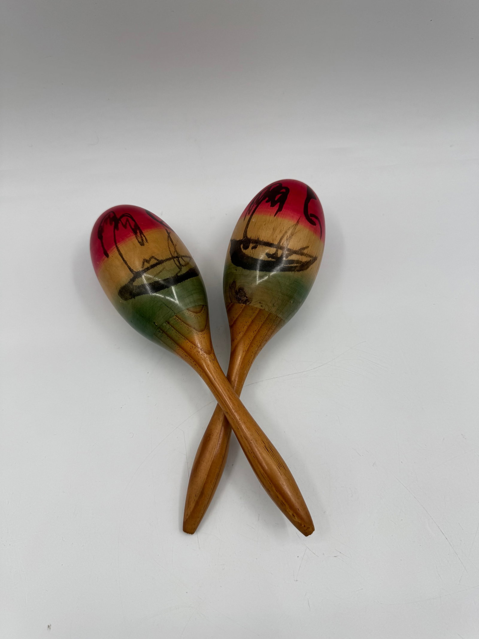 Pair of Hand-Painted Tropical Scene Maracas: Pair of wooden maracas, hand-painted with a tropical scene. Each maraca measures approximately 10.5 x 3 inches.