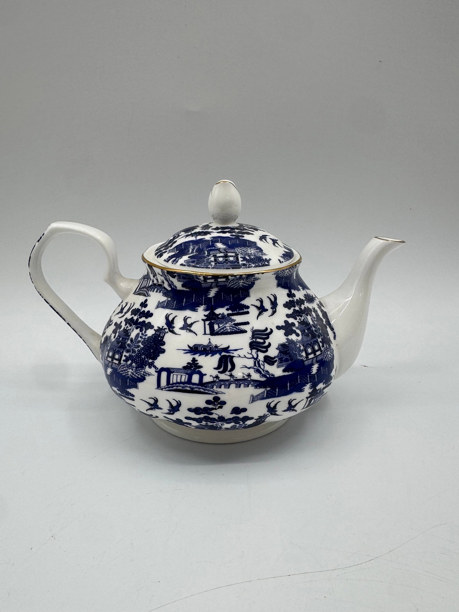 Rose of England Fine Bone China Teapot: Rose of England fine bone china teapot featuring a blue and white transferware design. Dimensions: 6" H x 9" L x 6" W.