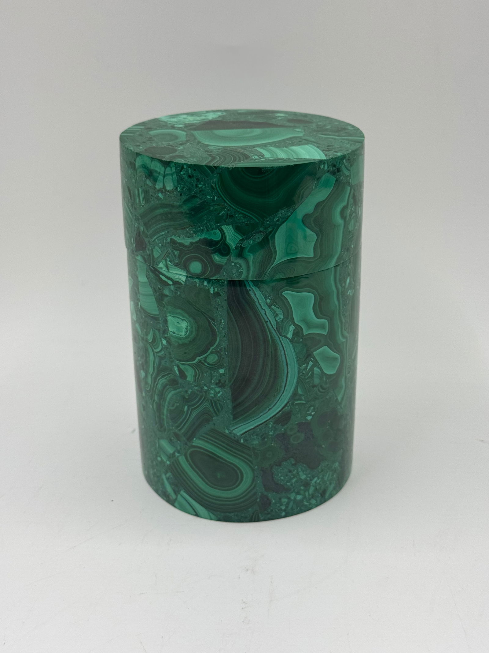 Malachite Box with Lid: Cylindrical malachite box with a fitted lid. The box is approximately 6 inches tall and 4 inches in diameter, showcasing the natural banding and patterns of the malachite stone.