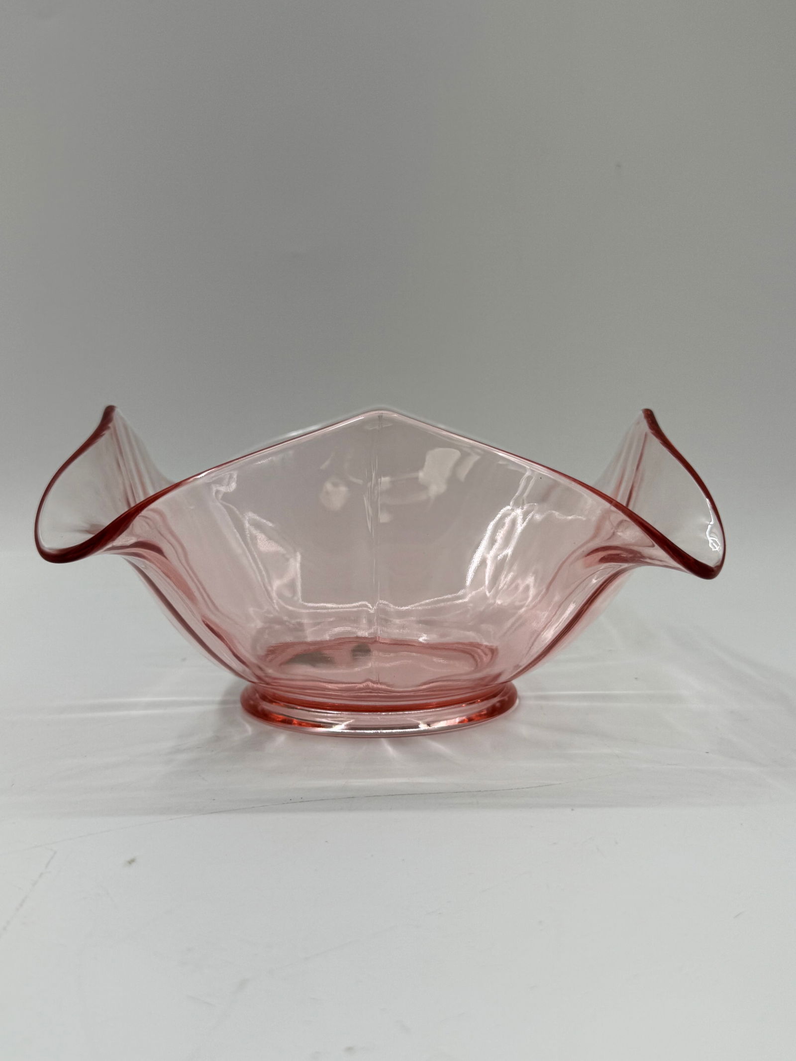 Vintage Pink Depression Glass Bowl, Ruffled Edge: Vintage pink depression glass bowl. Features a square shape with ruffled edges and a pedestal base. Measures approximately 7x7x4 inches.