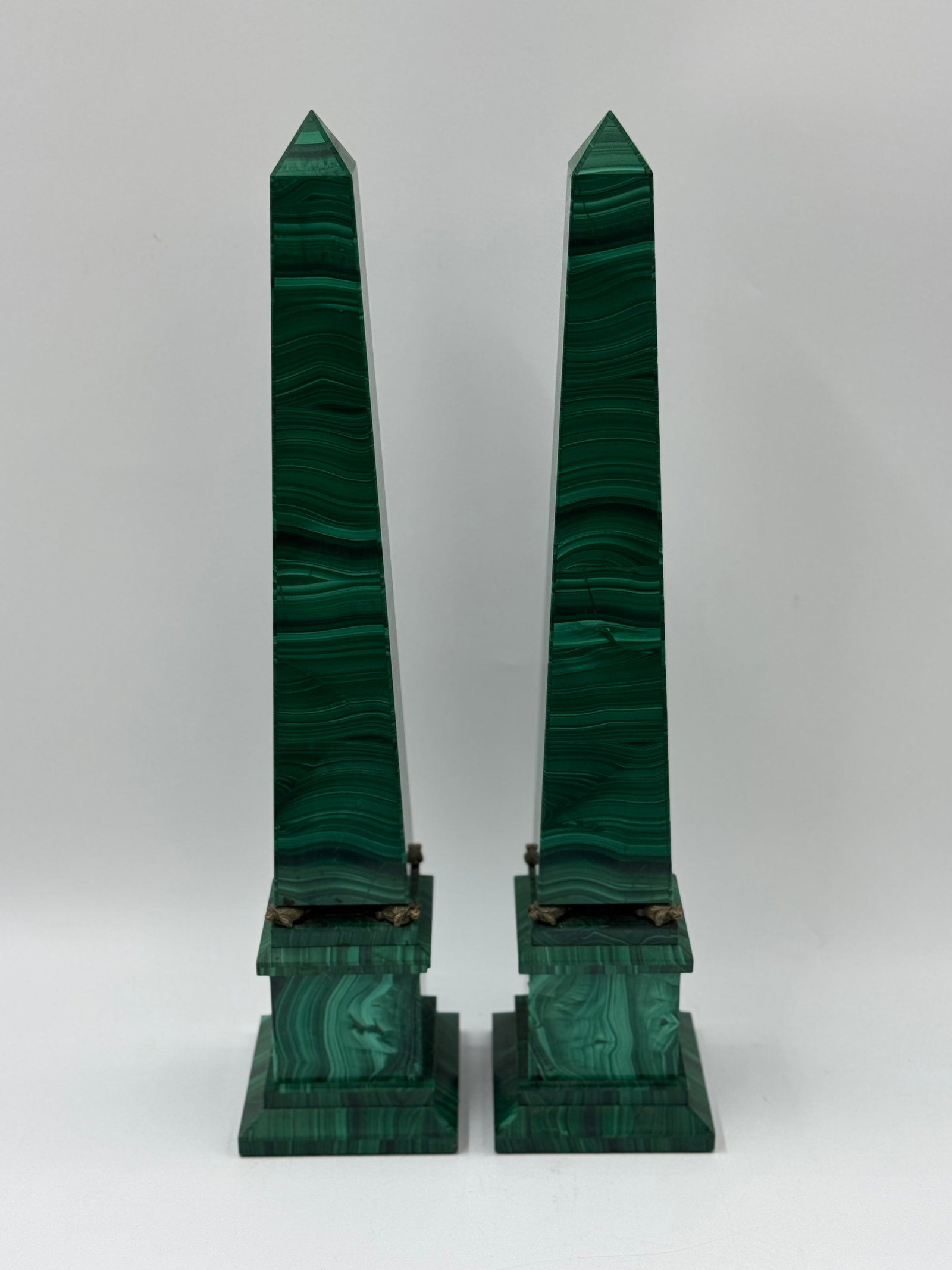 Pair of Malachite Obelisks: Pair of malachite obelisks, each mounted on a tiered base with bronze accents. Each measures approximately 18.5 x 4 x 4 inches.