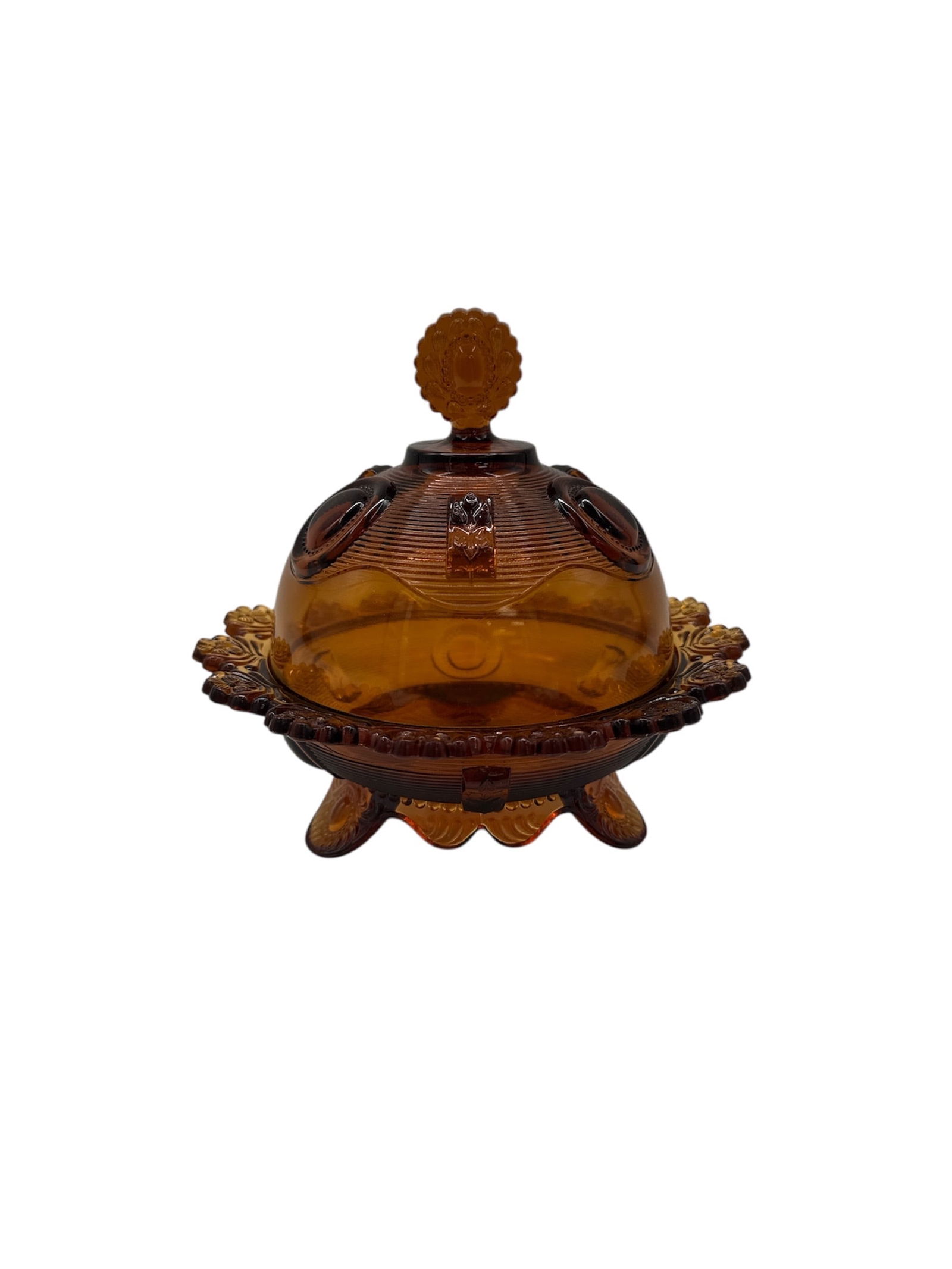 Vintage Amber Glass Butter Dish with Lid: Vintage amber glass butter dish with a decorative lid and base. The dish features a raised design and a sunburst finial. Measures approximately H:7in W:7in