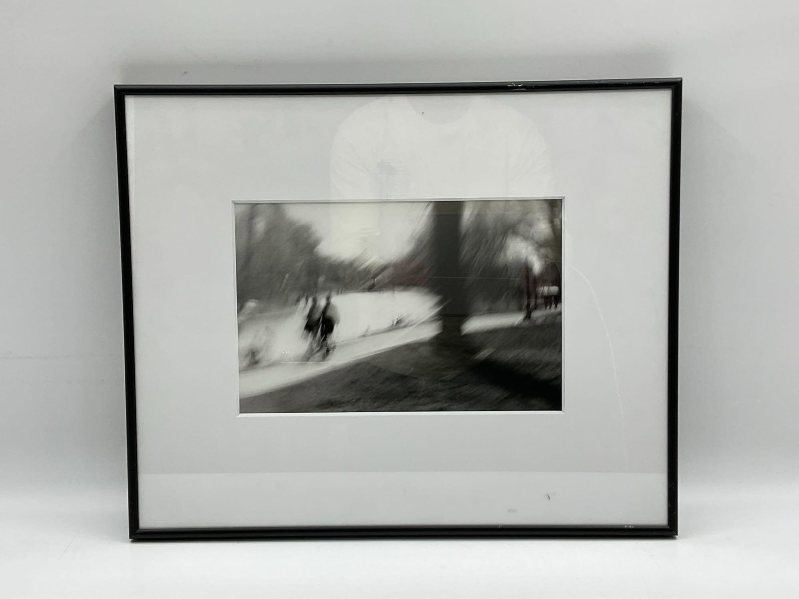 "A Walk in the Park" by Gail Rothenberg Silver Gelatin: Blurred black and white silver gelatin photograph depicting figures walking along a path in a park, evoking a sense of motion and atmosphere. Dimensions: H:17in L:20in Medium: photography