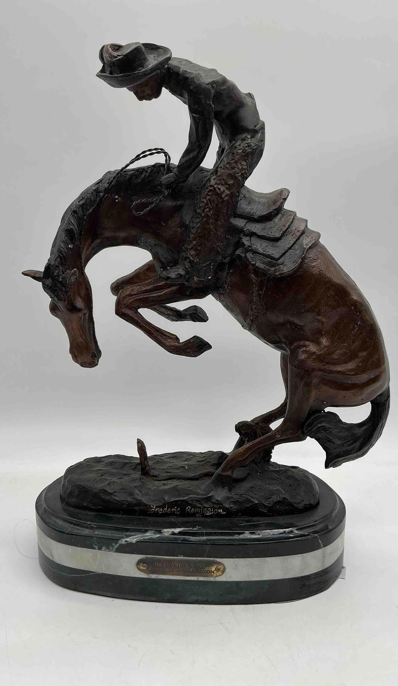 Frederic Remington Cowboy on Bucking Horse Sculpture: Bronze sculpture depicting a cowboy riding a bucking horse, mounted on an oval marble base, signed Frederic Remington.Medium: Bronze on marble base Dimensions: H:19in L:13in W:7in