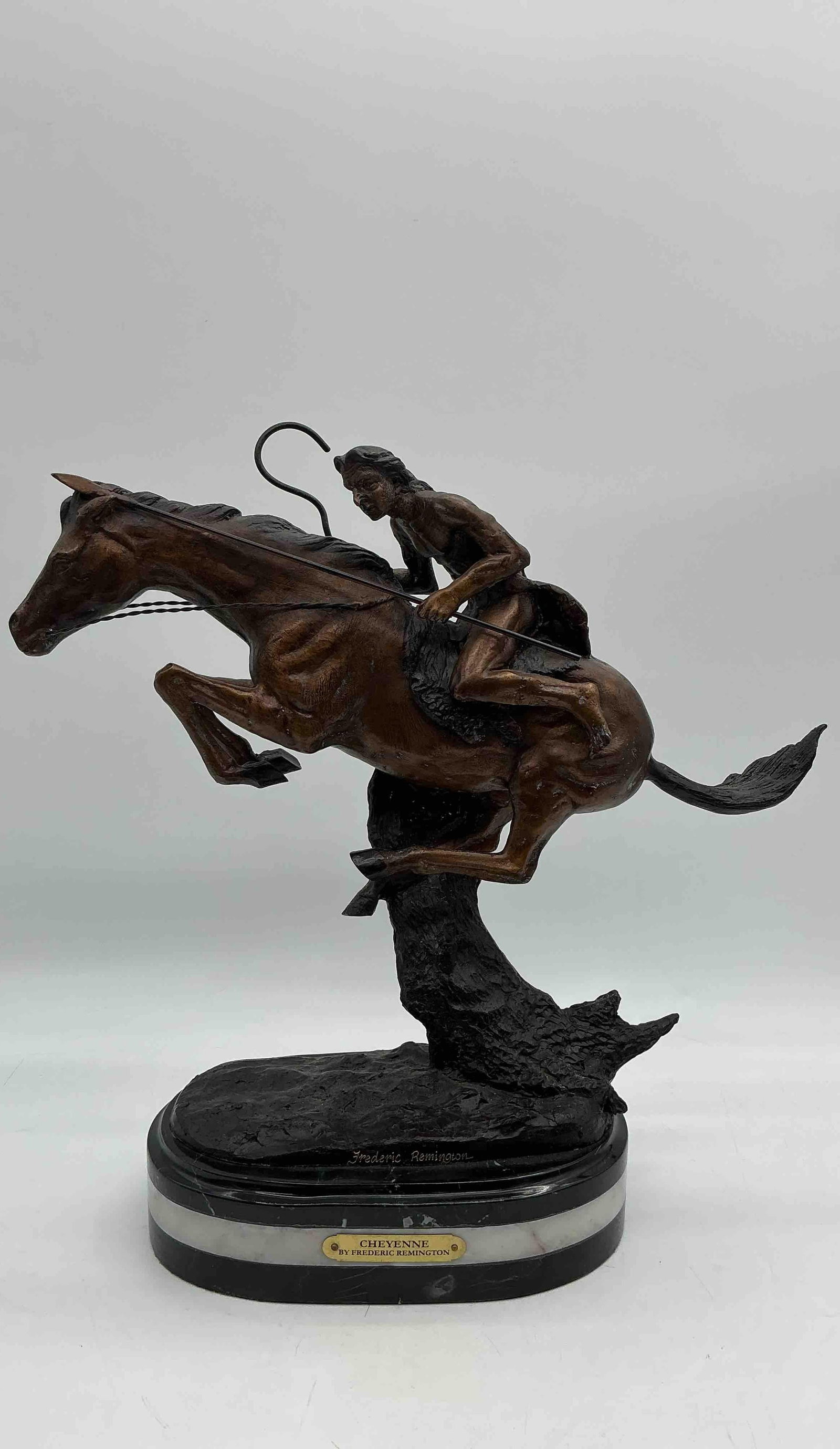 Frederic Remington The Cheyenne Sculpture: Bronze sculpture of a Native American warrior riding at full gallop with a spear in hand, mounted on an oval marble base, signed Frederic Remington.Medium: Bronze on marble base Dimensions: