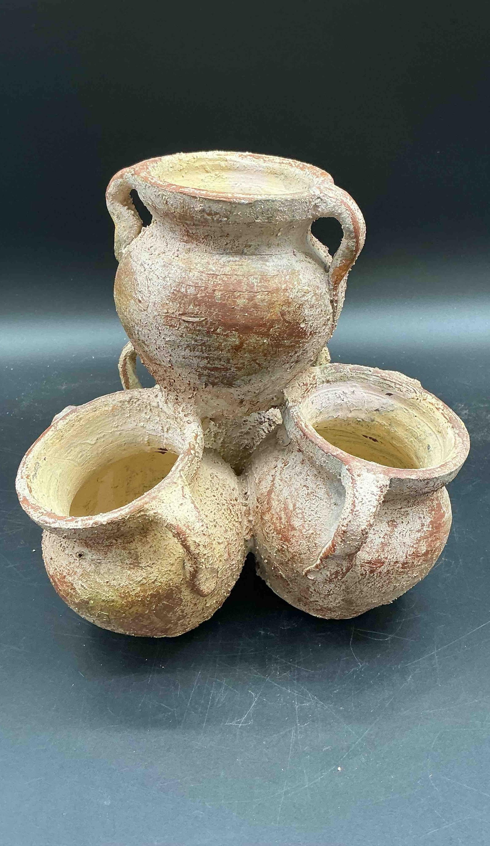 Rustic Cluster of Mini Clay Jars: A sculptural arrangement of three interconnected rustic mini clay jars with textured surfaces and natural patina. The piece appears handmade and evokes a traditional, weathered look, suitable for rust