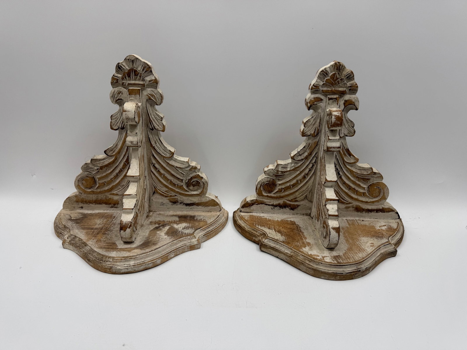 Pair of Carved Wood Wall Shelves: Pair of decorative wall shelves, each featuring ornate carved details and a distressed white finish. Approximate dimensions: 14 x 13 x 8 inches each.