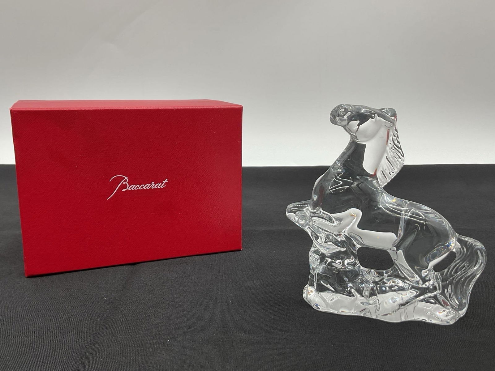 Baccarat Crystal Horse Figurine in Original Box: Beautifully sculpted Baccarat clear crystal horse figurine, showcasing a graceful horse resting among foliage. Rendered in high-polish crystal with fluid lines and naturalistic detail, the piece exemp