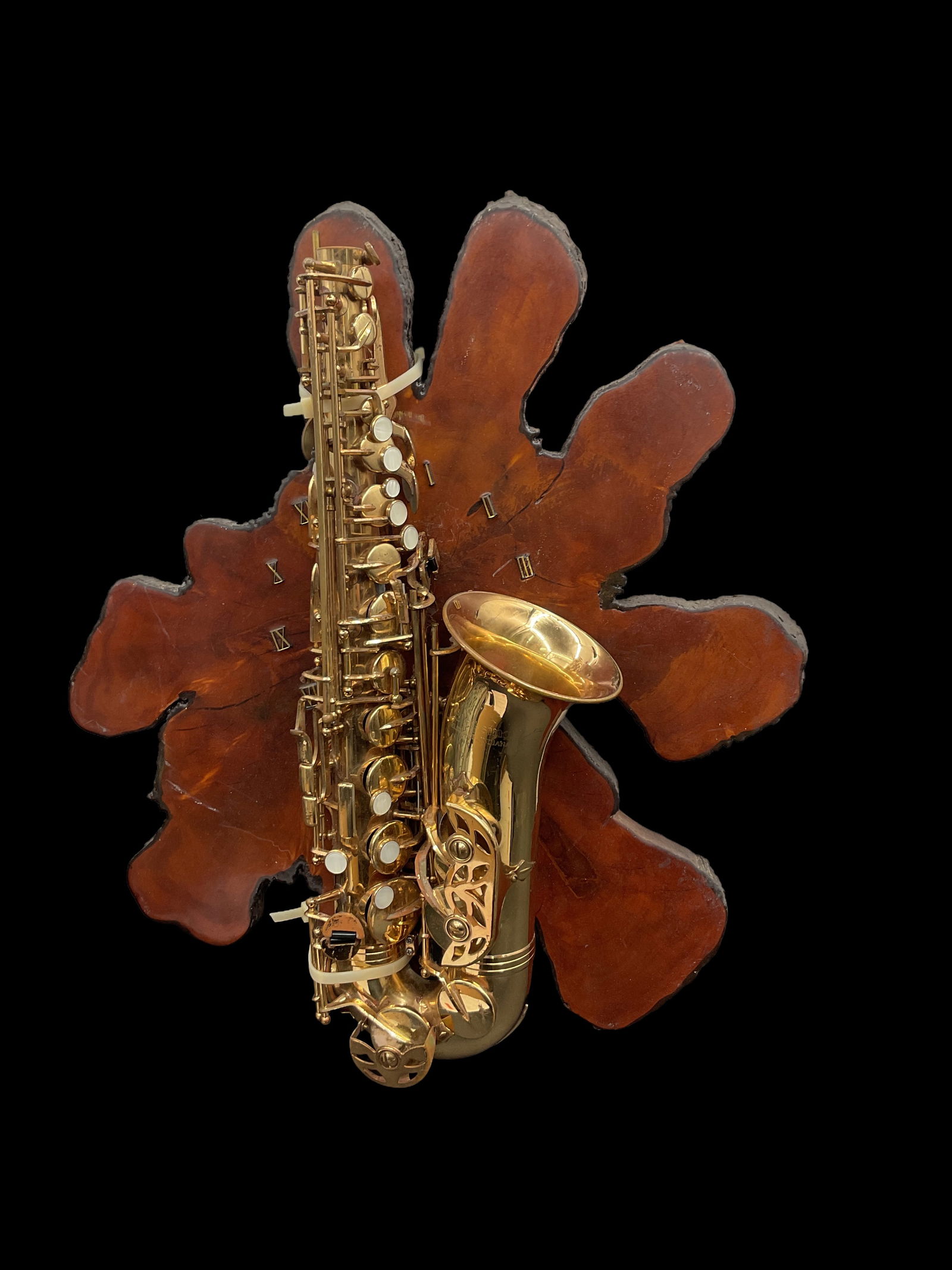 Decorative Saxophone on Natural Wood Slab: Unique display piece featuring a brass-tone saxophone mounted onto a large, organically shaped natural wood slab. Created as a decorative art object rather than a functional instrument.