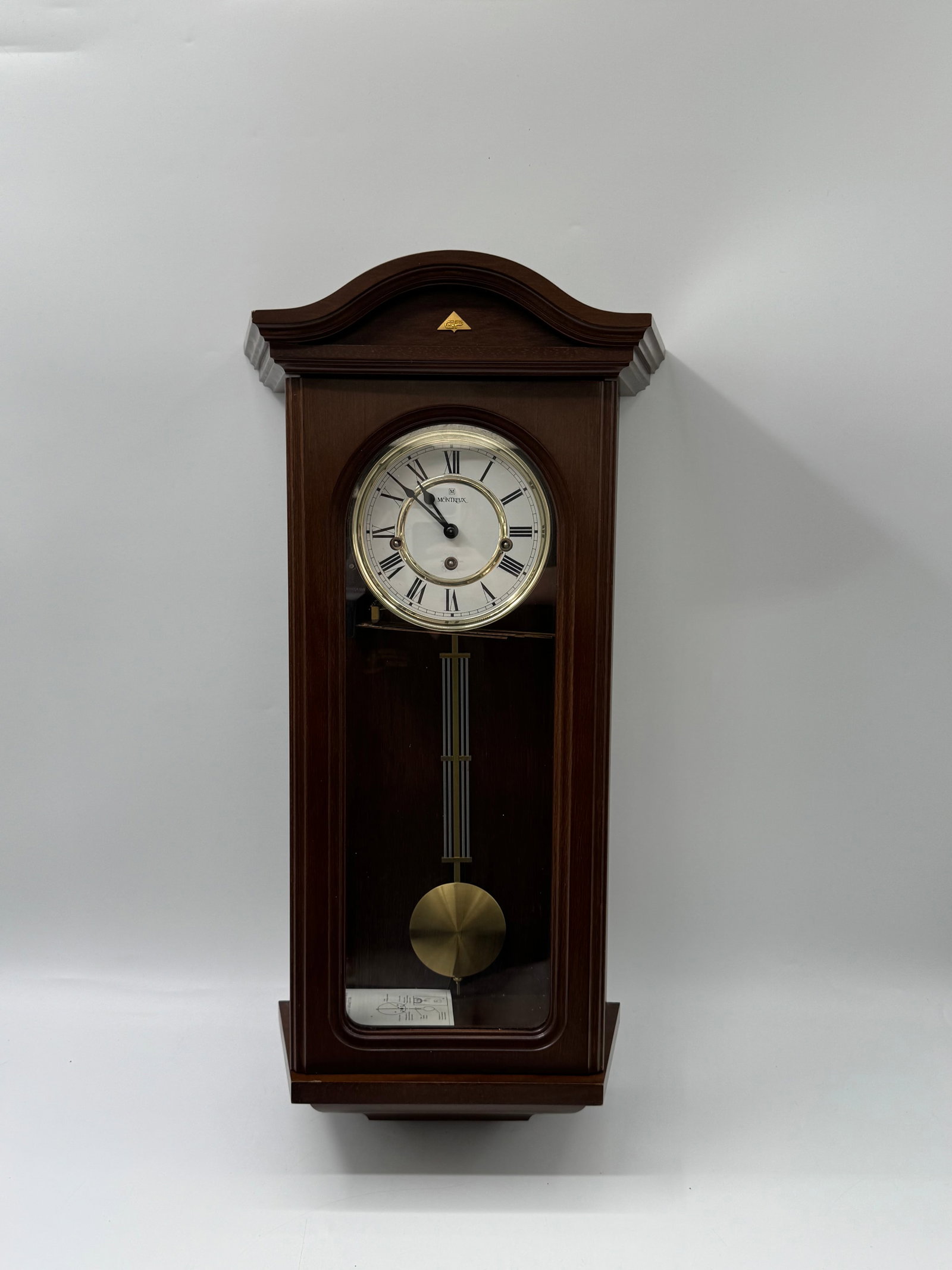 RARE Jostens Wall Clock with Pendulum: Jostens wall clock with a pendulum. Features a dark wood case and a white face with Roman numerals. Measures approximately 26 x 13 inches.