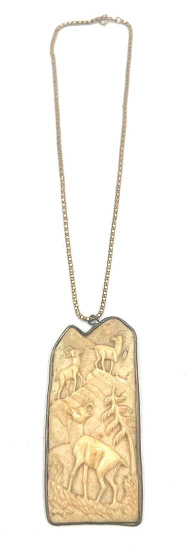 Alexis Bittar Style Carved Lucite Deer Pendant Necklace: Statement pendant necklace in the style of Alexis Bittar, featuring a carved Lucite or resin panel with a woodland scene of three deer in relief. Set in a dark metal bezel and suspended from a gold-to