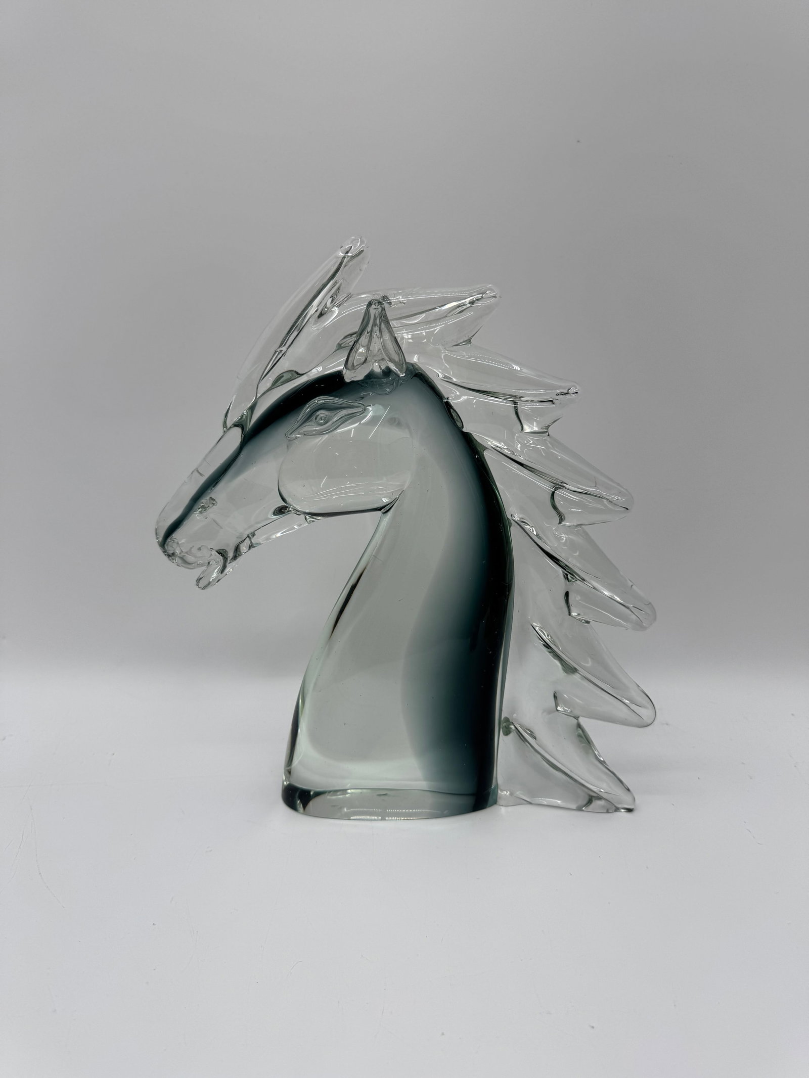 Murano Gray Glass Horse Head Sculpture: Gray glass sculpture in the style of Murano, depicting a horse head with stylized mane. Approximately 13 x 12 inches.