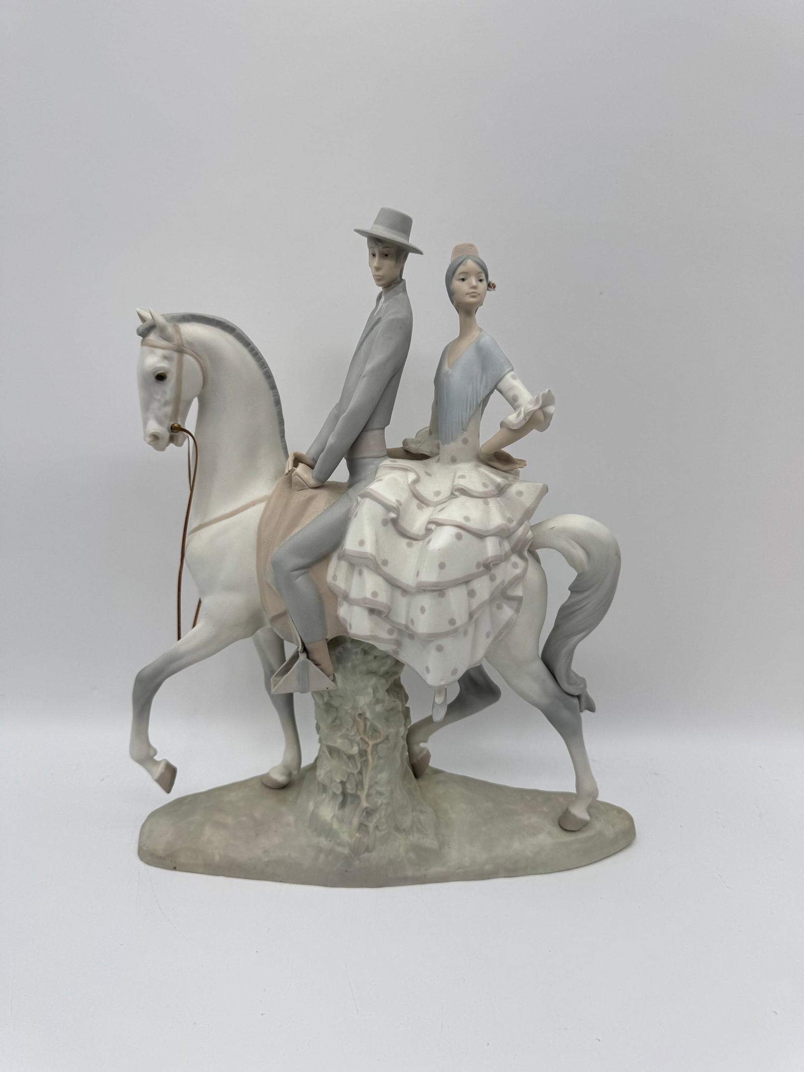 Lladro 'Spanish Romance' Porcelain Figurine: Lladro porcelain figurine titled 'Spanish Romance' depicting a man and woman riding a horse. Marked on the bottom. Measures approximately 18 x 14 inches.