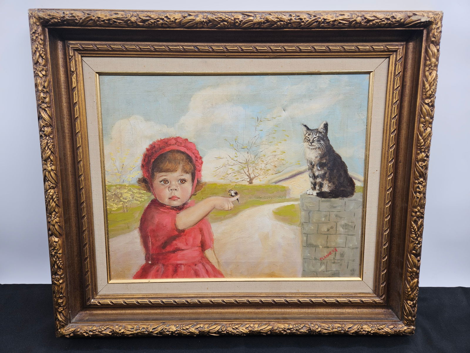 “Girl in Red with Cat?? by Flannery: Charming vintage oil painting depicting a young girl in a red dress and bonnet holding a flower, gesturing toward a cat perched on a stone wall. Signed “Flannery” lower right. The composit