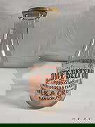 Slate Belt Dairy Milk Bottle - Box 5 - Photo 13: A clear glass milk bottle from Slate Belt Dairy, located in Bangor, PA. The bottle features bold orange lettering advertising "Homogenized, Pasteurized & Clarified Milk &