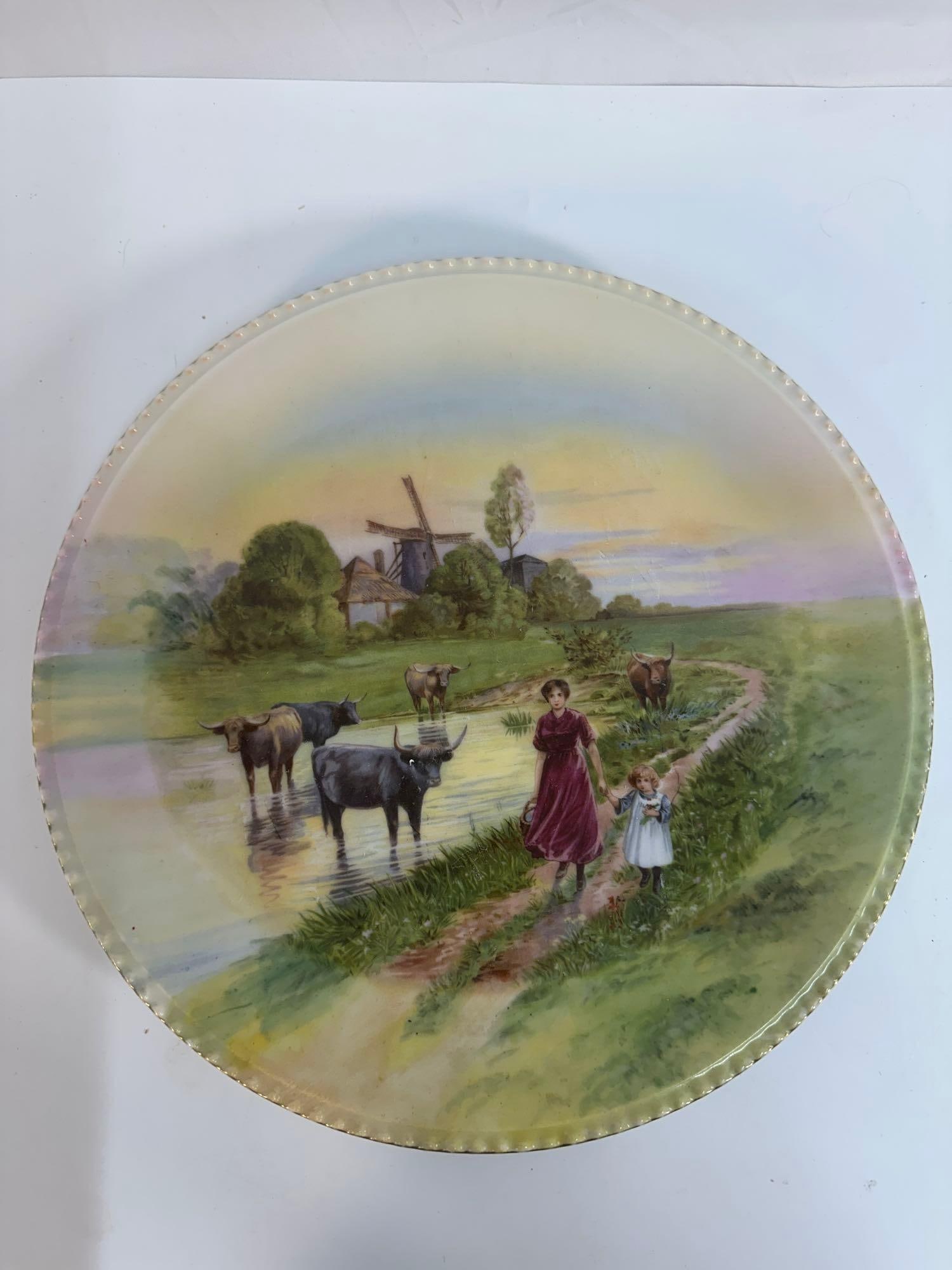 Vintage Schwarzburg Porcelain Cow Plate - Box 7 - Photo 18 - German:  This vintage porcelain plate features a beautifully detailed pastoral scene with a woman in a burgundy dress and a child standing near a small body of water, surrounded by cows and horses. A