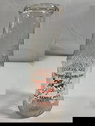 MacKenzie Dairy Farm Milk Bottle - Box 5 - Photo 13: A textured glass dairy bottle from MacKenzie Dairy Farm, featuring orange printed lettering and an illustration of a cow. The bottle’s quilted diamond pattern suggests it was used for cream or