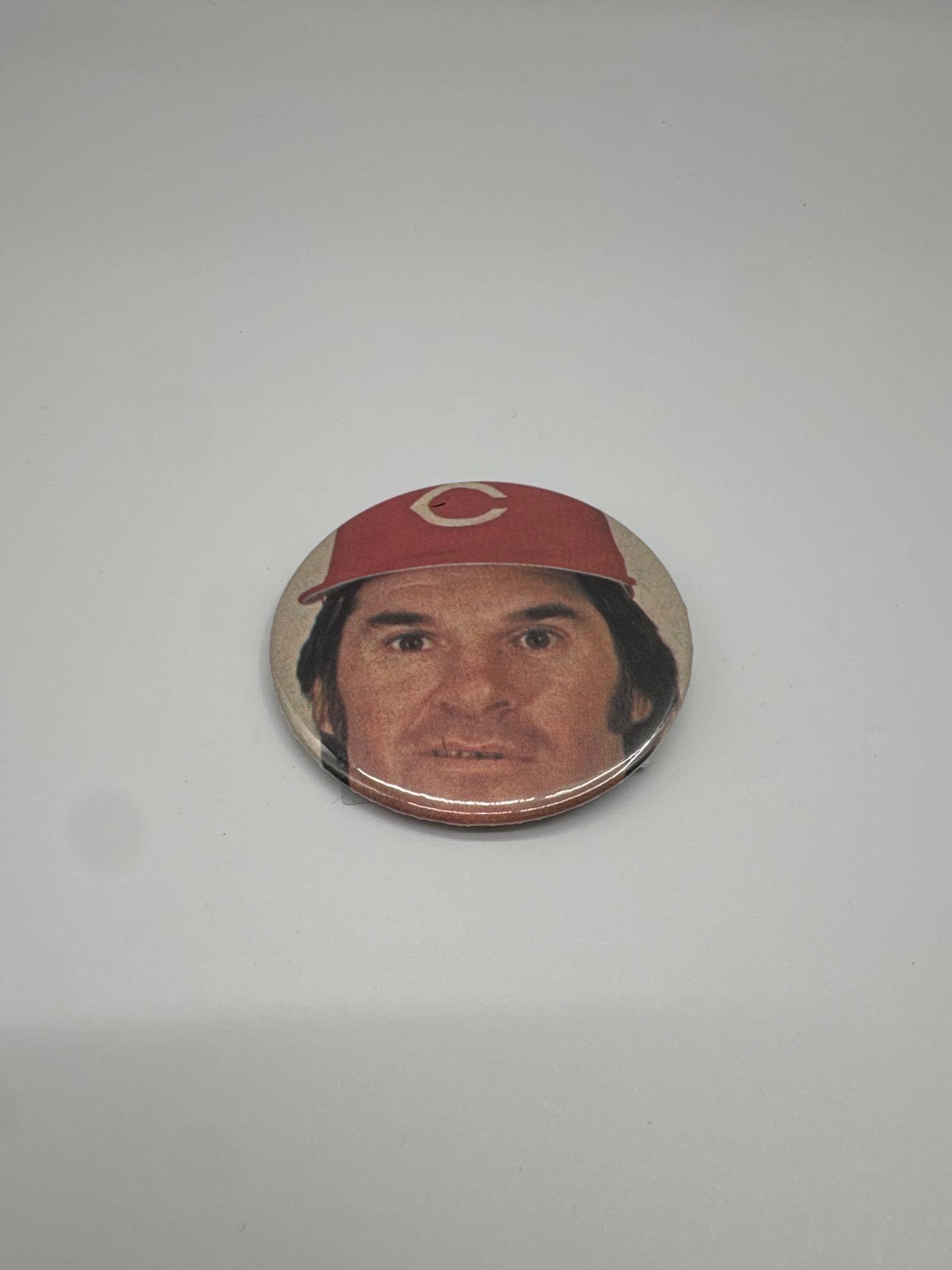Vintage Pete Rose Cincinnati Reds Pinback Button: A vintage pinback button featuring Pete Rose, legendary MLB hitter and member of the Cincinnati Reds. Likely produced during the 1970s–1980s, this button showcases Rose in his Reds cap and is a