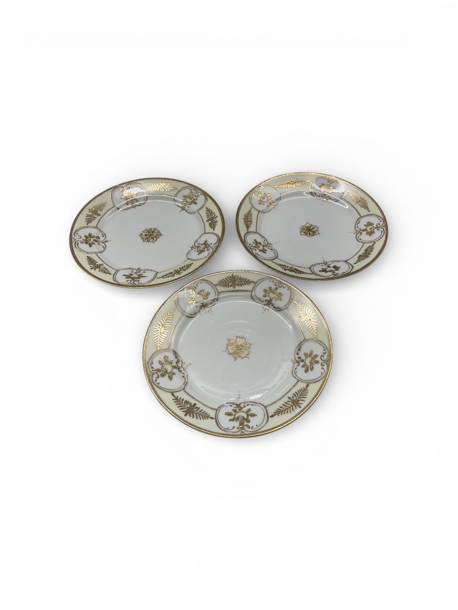 Set of Three Japanese Nippon Porcelain Plates with Gilt and Floral Decoration: This set of three porcelain plates was produced in Japan during the Nippon export period and bears a wreath mark with an M and the word Nippon, associated with Morimura Brothers and related export