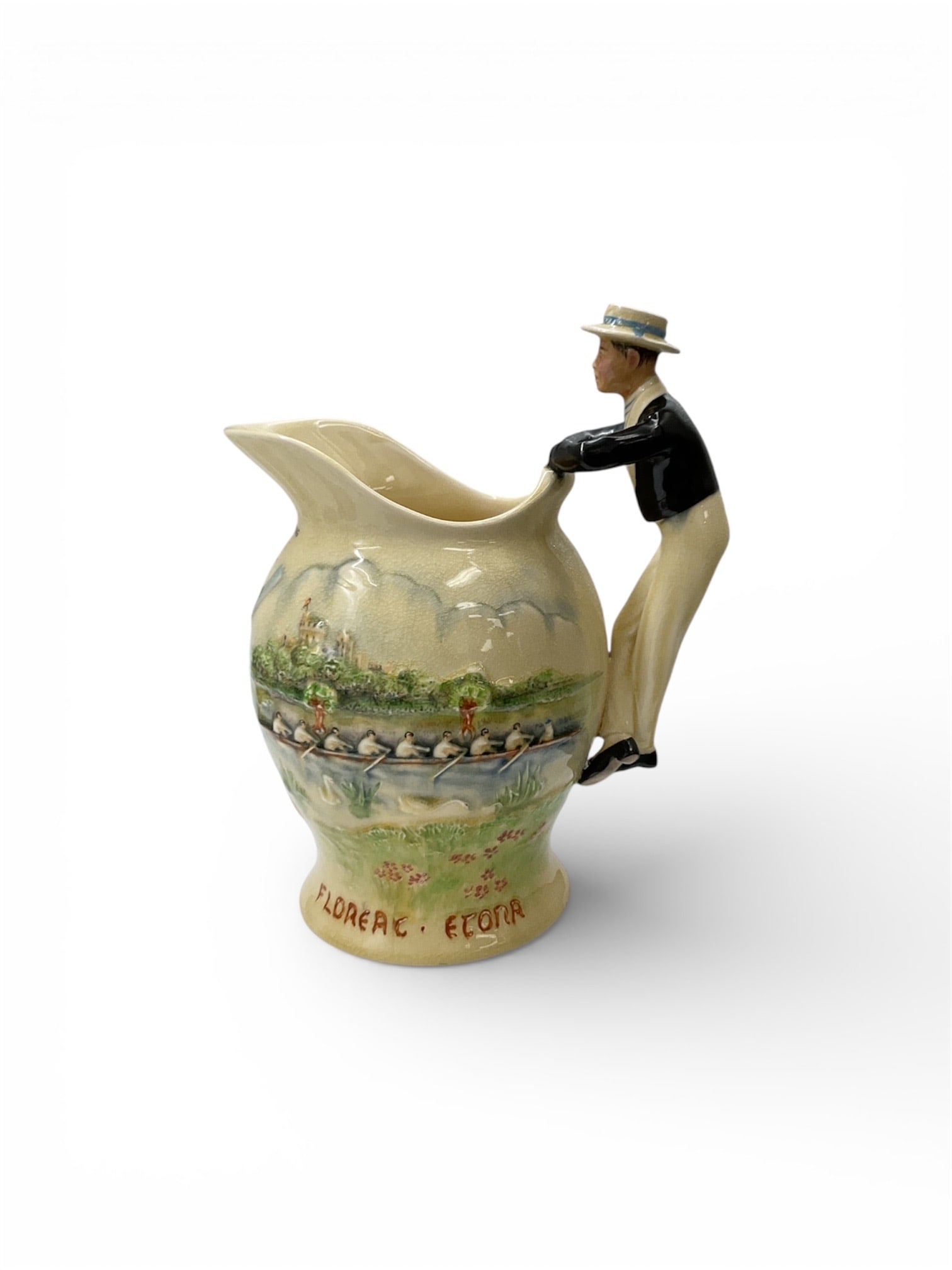 RARE English Musical Souvenir Figural Pitcher with Scenic Eton College Decoration: This distinctive English souvenir pitcher incorporates a built-in musical movement and features a sculptural figural handle depicting a gentleman leaning against the rim. The cream-colored ceramic