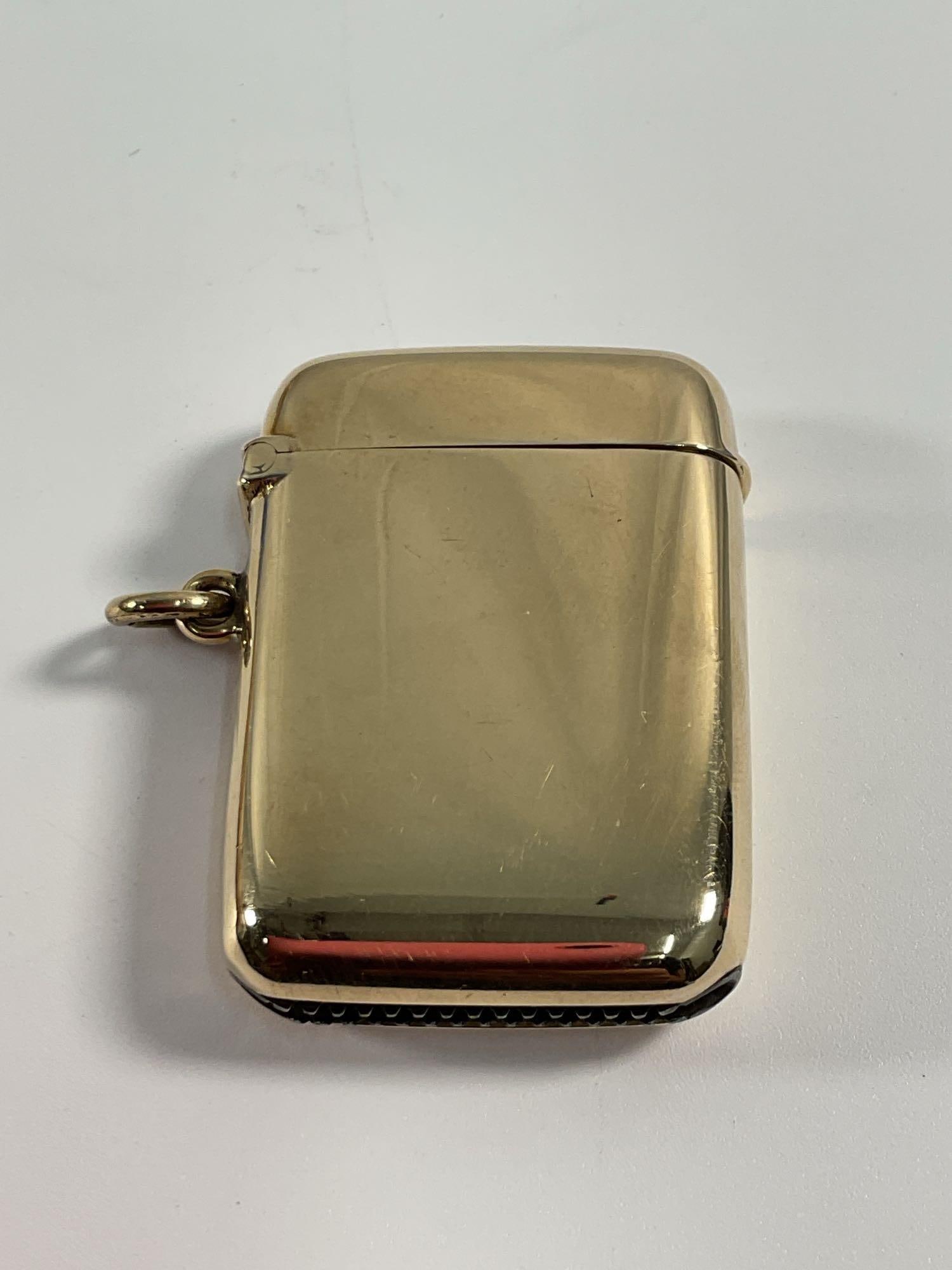 Antique (1864) 9kt Gold Vesta Case: This is a classic gold Vesta case, also known as a match safe. It features a smooth, polished exterior with a slightly curved design and a small loop for attachment to a chain or fob. The case
