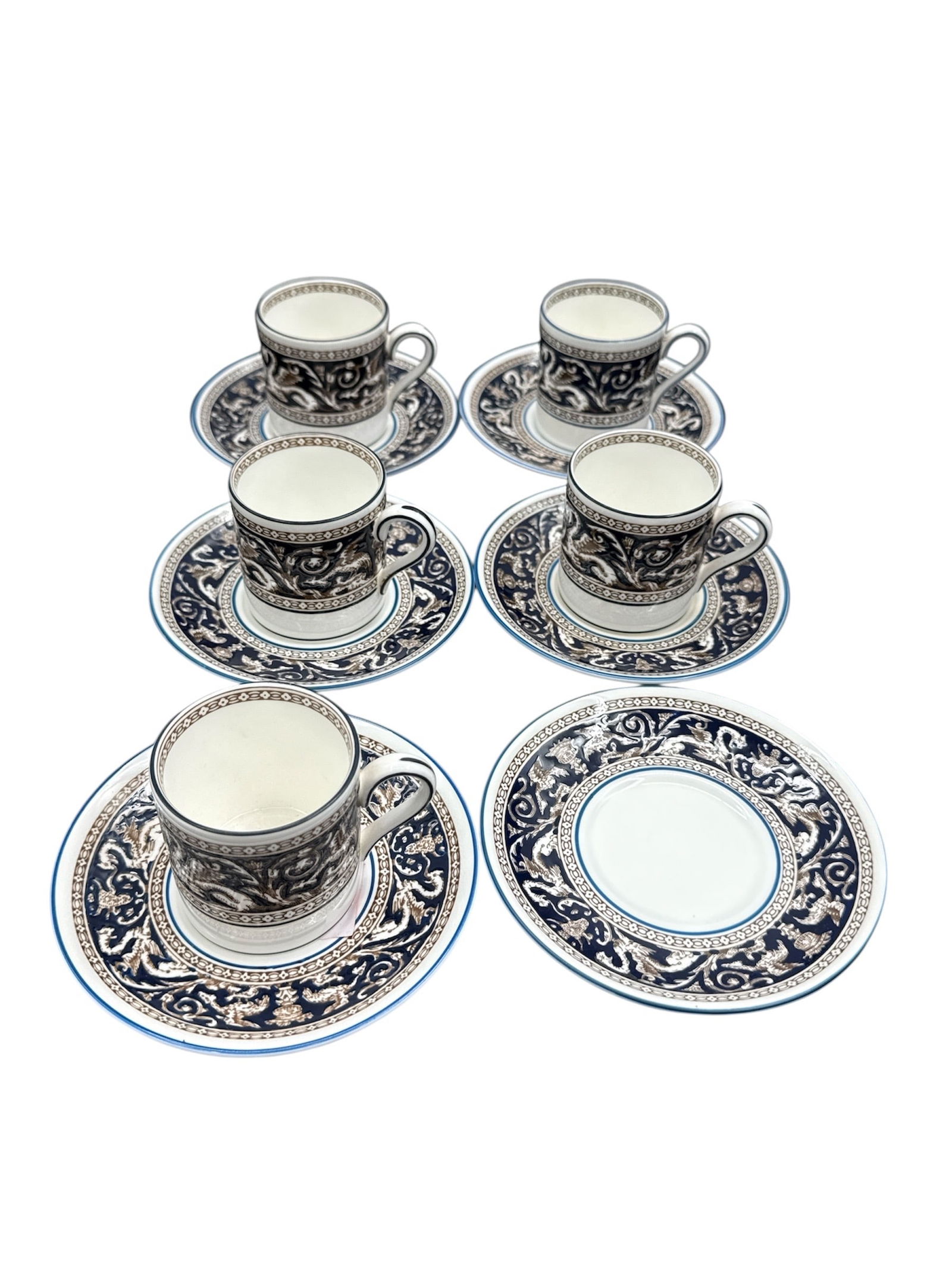 Wedgwood Black and White Demitasse Cup and Saucer Set: This lot features a classic Wedgwood black and white demitasse set consisting of five cups and six matching saucers, with one cup missing from the original set. The pieces display an elegant