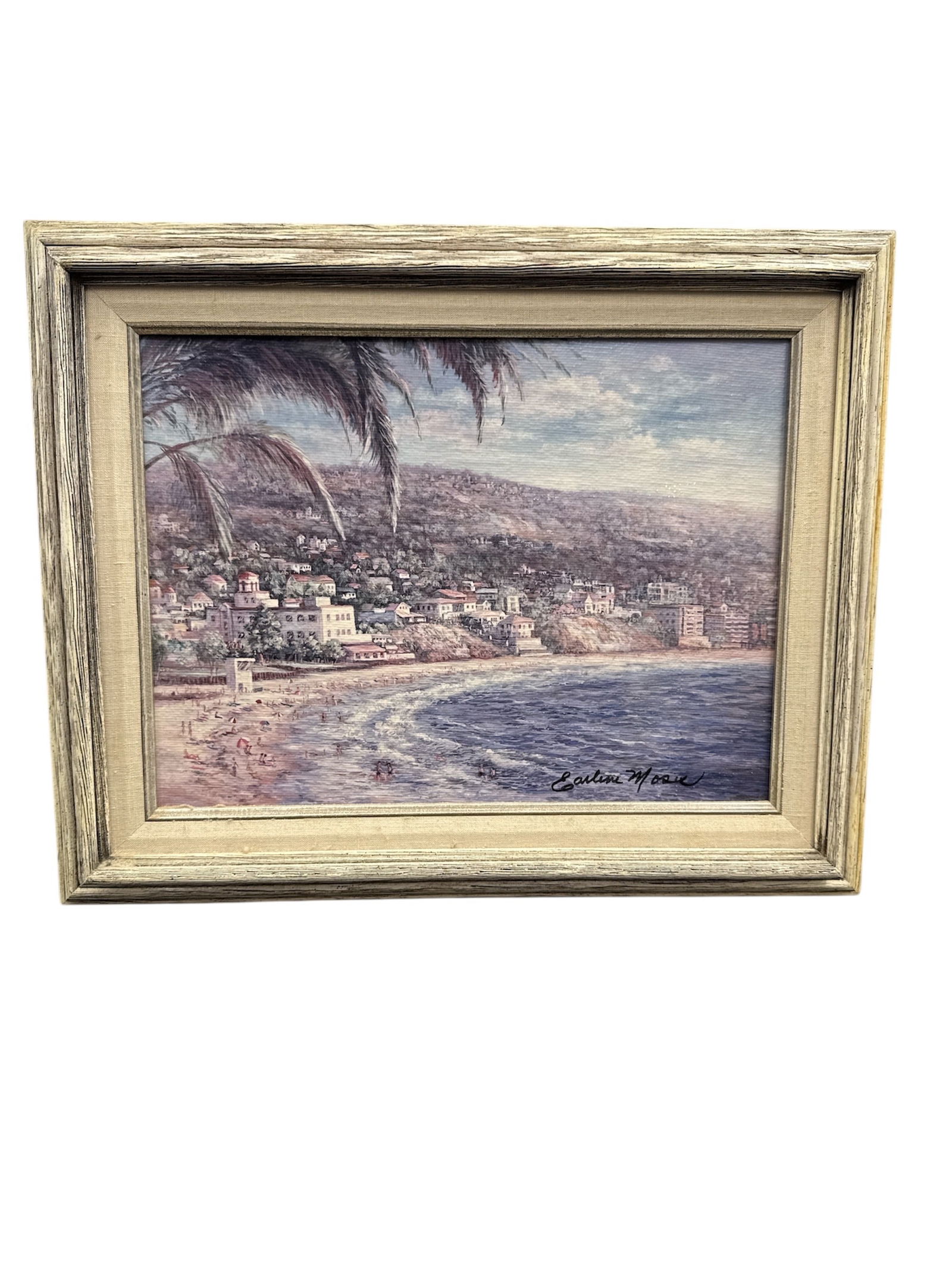 Earlene Moore Laguna Riviera Limited Edition Artwork 1991: This framed limited edition artwork titled Laguna Riviera is by Earlene Moore and dates to 1991. The piece depicts a coastal shoreline scene with rolling surf, hillside architecture, and palm trees